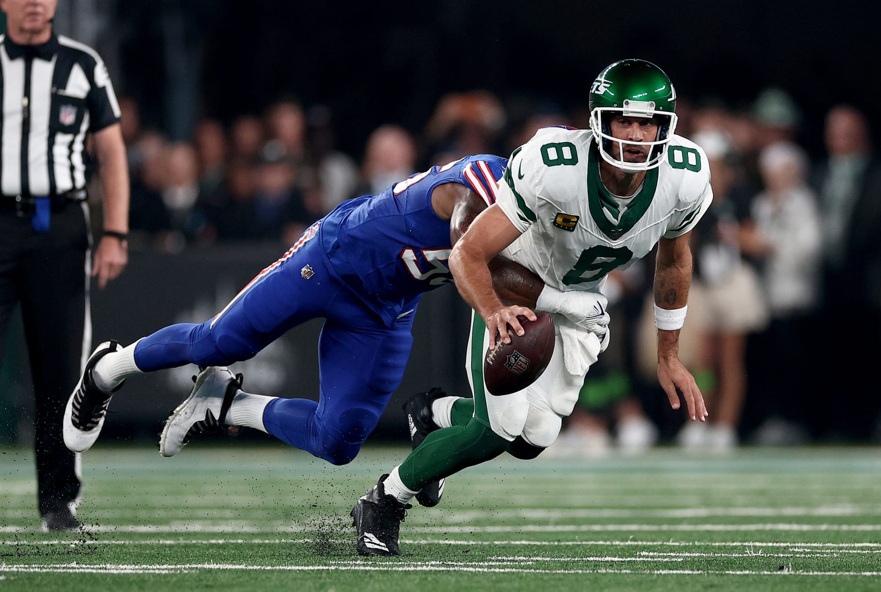 EAST RUTHERFORD, NEW JERSEY - SEPTEMBER 11: Aaron Rodgers #8 of the New York Jets is sacked by Leonard Floyd #56 of the Buffalo Bills in the first quarter at MetLife Stadium on September 11, 2023 in East Rutherford, New Jersey. Rodgers was helped off the field after this play. (Photo by Elsa/Getty Images)