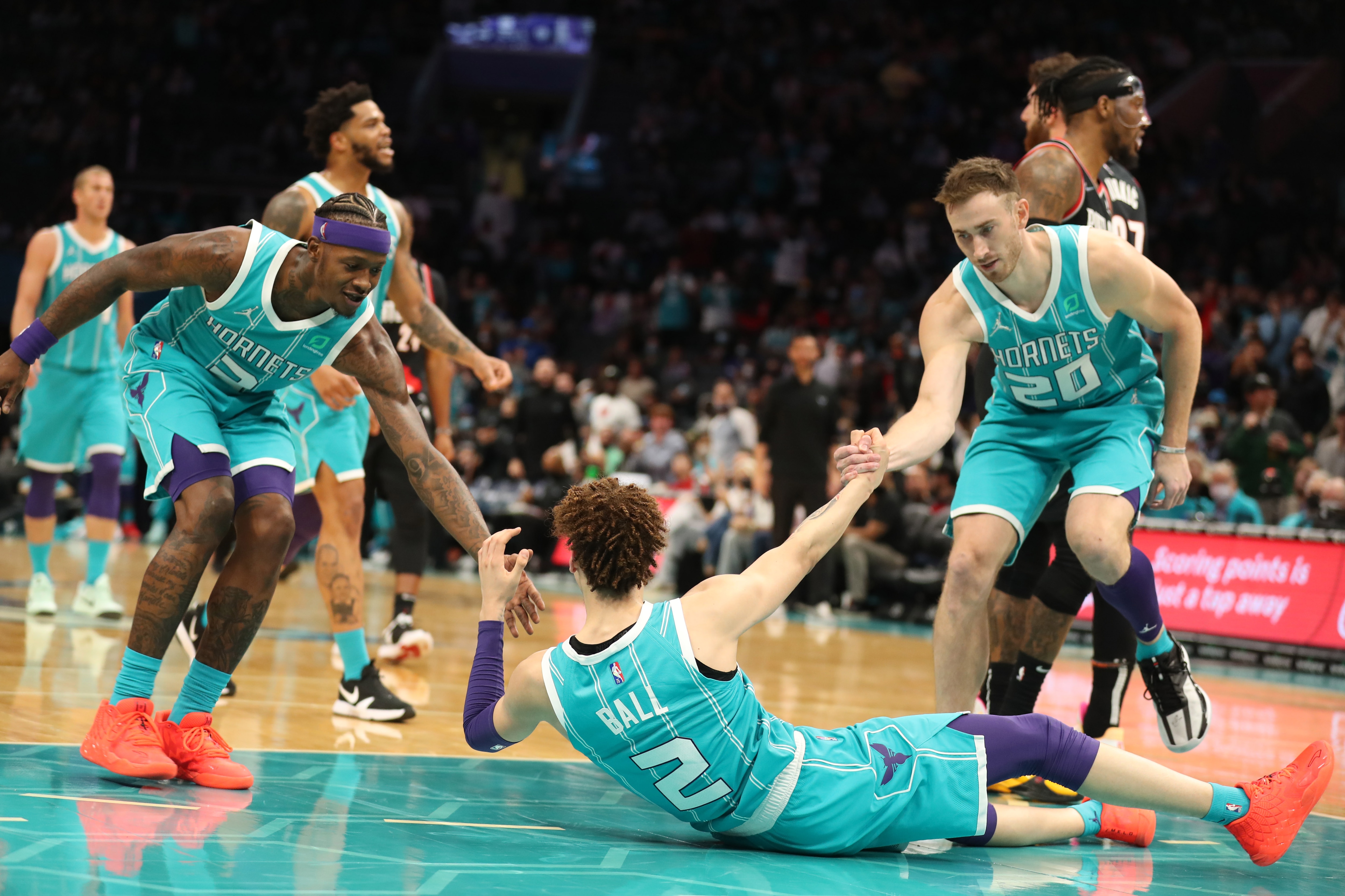 CHARLOTTE, NC - OCTOBER 31: Terry Rozier #3 and Gordon Hayward #20 help up LaMelo Ball #2 of the Charlotte Hornets on October 31, 2021 at Spectrum Center in Charlotte, North Carolina. NOTE TO USER: User expressly acknowledges and agrees that, by downloading and or using this photograph, User is consenting to the terms and conditions of the Getty Images License Agreement.  Mandatory Copyright Notice:  Copyright 2021 NBAE (Photo by Brock Williams-Smith/NBAE via Getty Images)