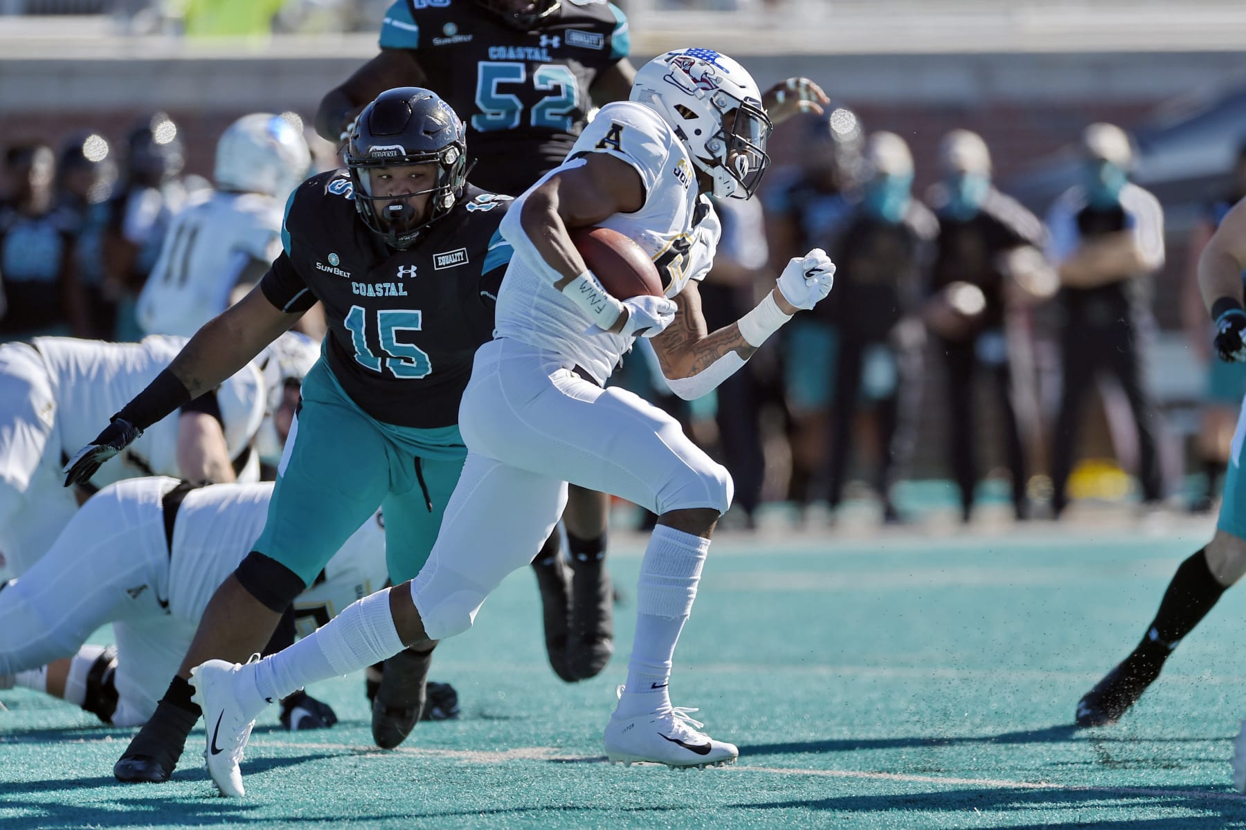 Appalachian State's Camerun Peoples, center, rushes while defended by Coastal Carolina's Jerrod Clark (15) during the first half of an NCAA college football game, Saturday, Nov. 21, 2020, in Conway, S.C. (AP Photo/Richard Shiro)