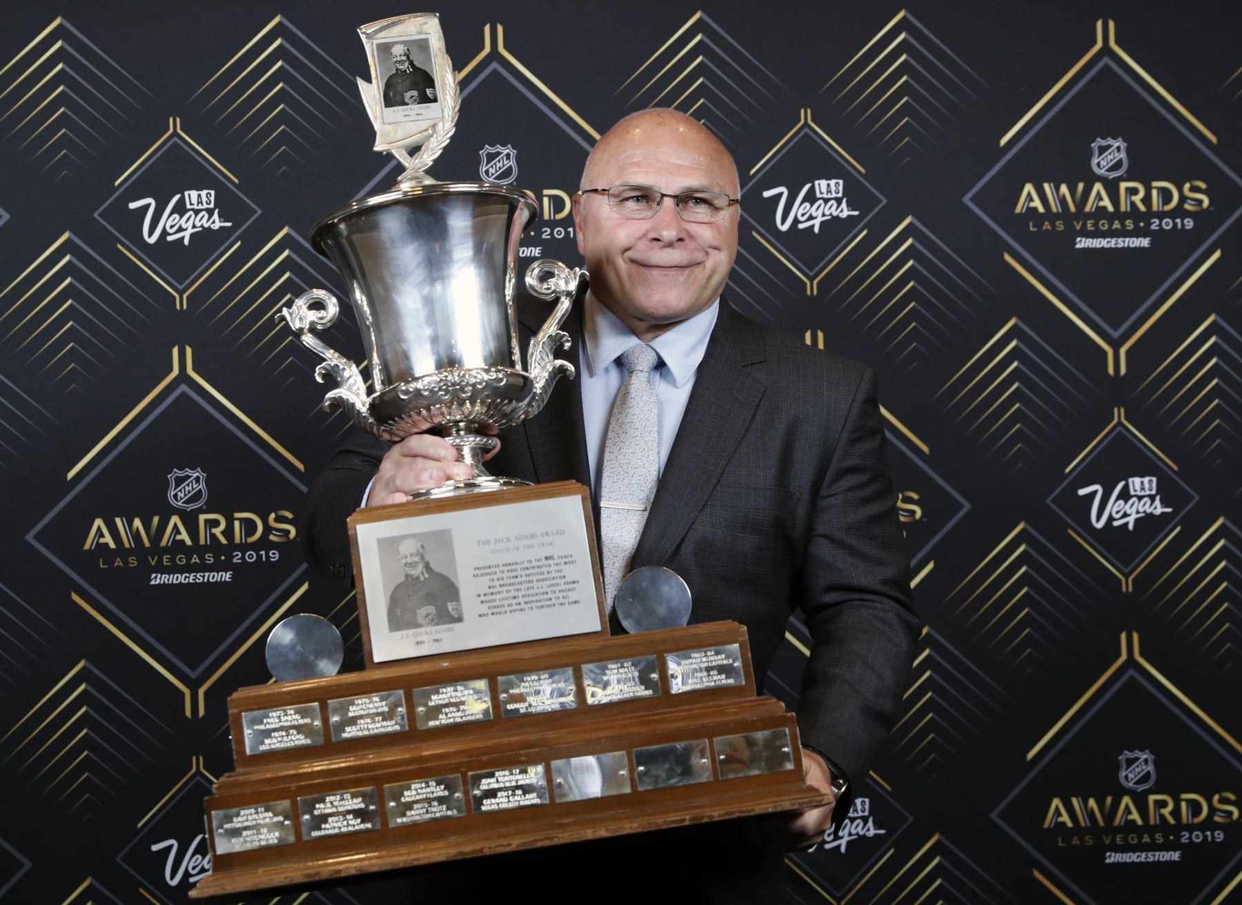 Barry Trotz of the New York Islanders poses with the Jack Adams Award after winning the award at the NHL Awards, Wednesday, June 19, 2019, in Las Vegas. (AP Photo/John Locher)