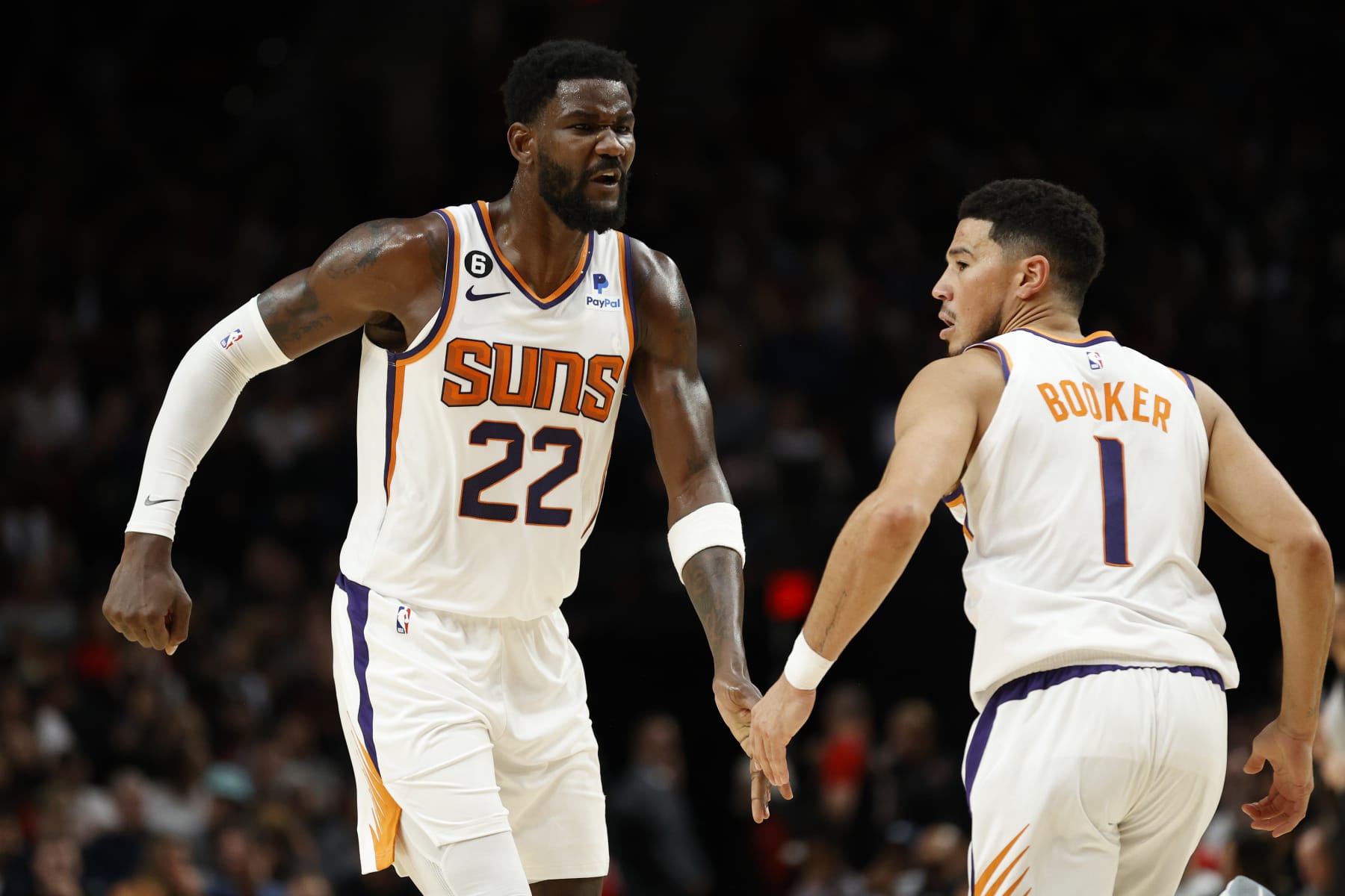 PORTLAND, OREGON - OCTOBER 21: Deandre Ayton #22 and Devin Booker #1 of the Phoenix Suns react during the second quarter against the Portland Trail Blazers during the second quarter at Moda Center on October 21, 2022 in Portland, Oregon. NOTE TO USER: User expressly acknowledges and agrees that, by downloading and or using this photograph, User is consenting to the terms and conditions of the Getty Images License Agreement. (Photo by Steph Chambers/Getty Images)