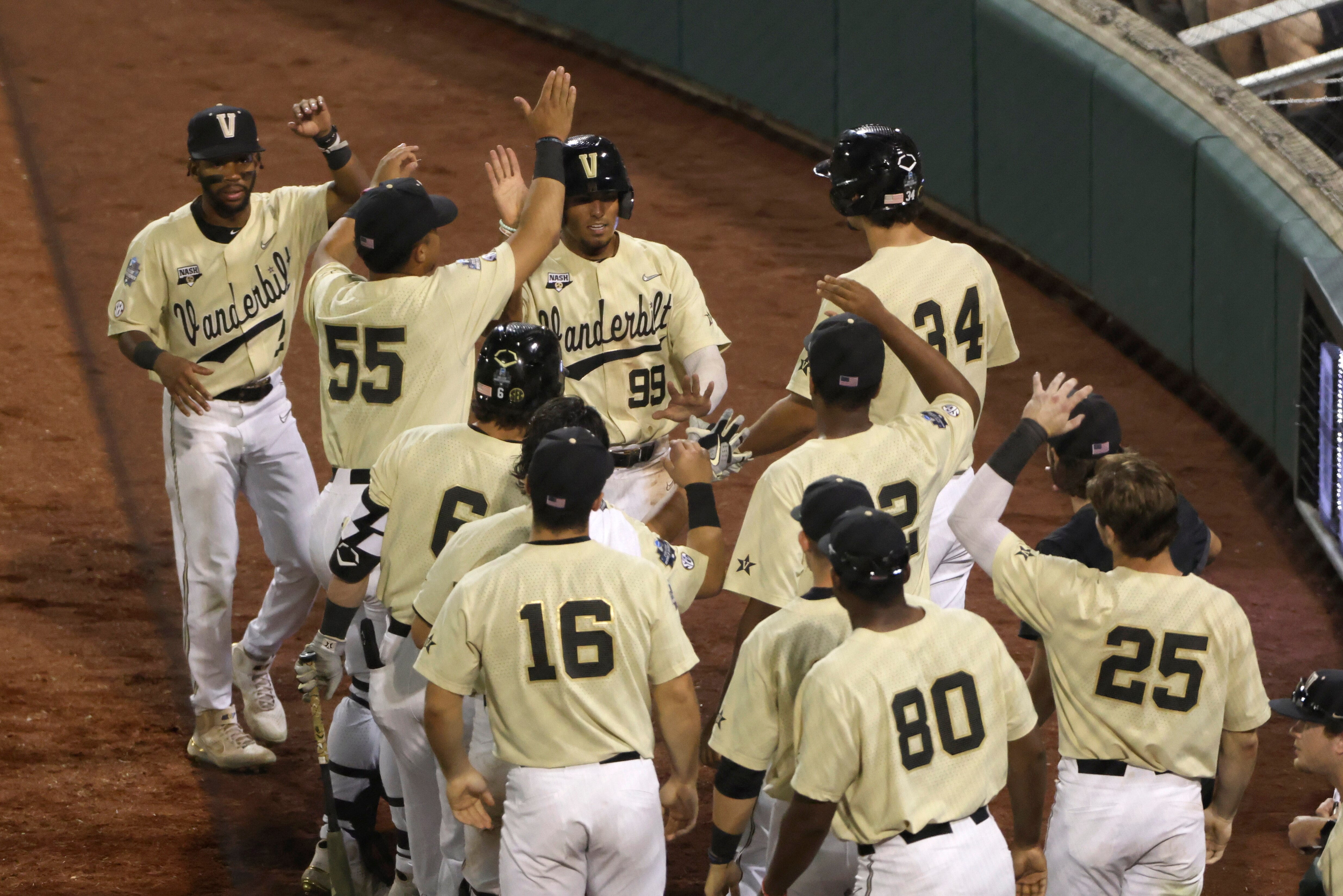 Vanderbilt's Jayson Gonzalez (99) celebrates with teammates after scoring on a single by Carter Young during the seventh inning against Mississippi State in Game 1 of the NCAA College World Series baseball finals, Monday, June 28, 2021, in Omaha, Neb. (AP Photo/Rebecca S. Gratz)