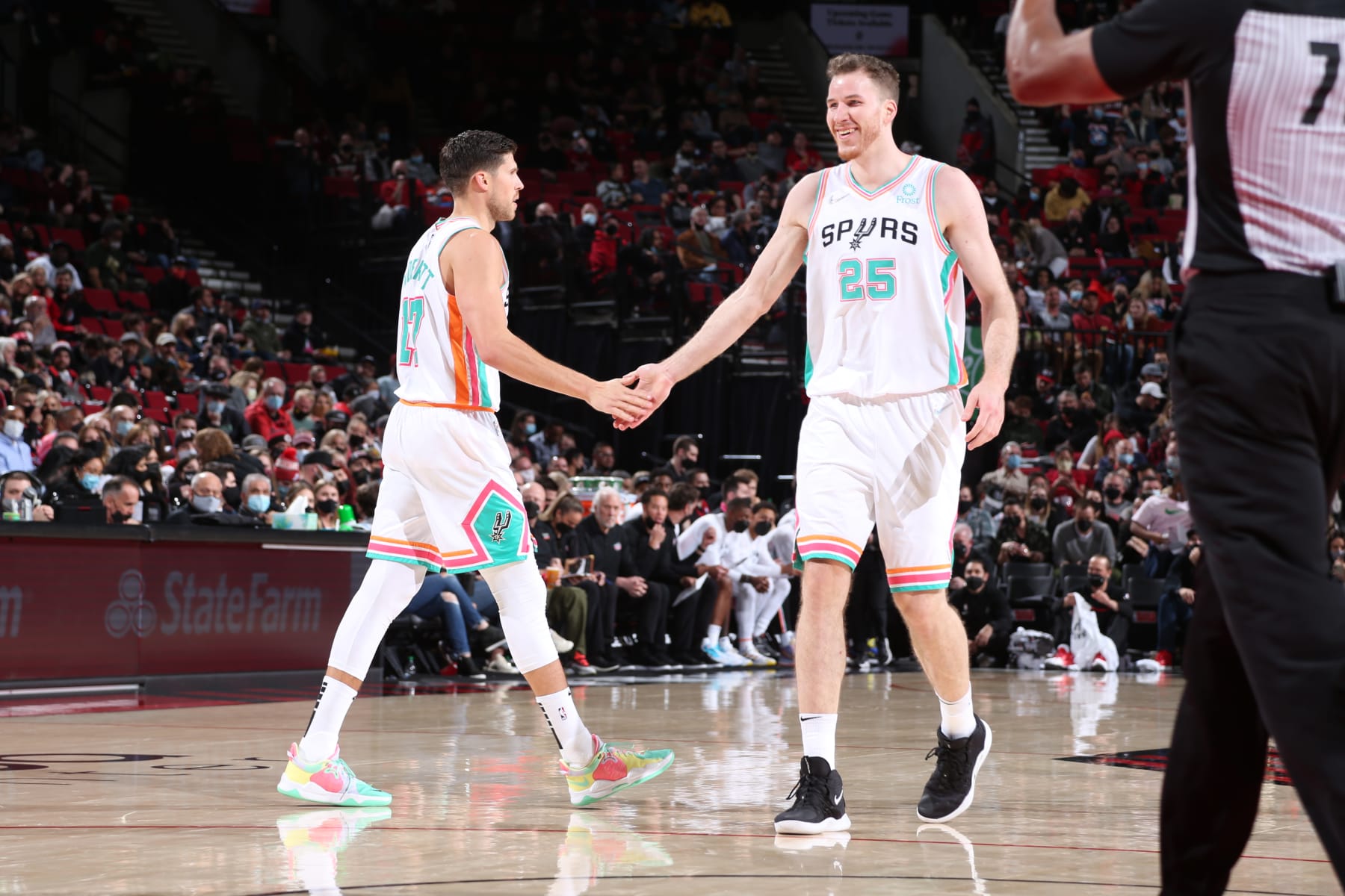 PORTLAND, OR - DECEMBER 2: Doug McDermott #17 and Jakob Poeltl #25 of the San Antonio Spurs hi-five during the game against the Portland Trail Blazers on December 2, 2021 at the Moda Center Arena in Portland, Oregon. NOTE TO USER: User expressly acknowledges and agrees that, by downloading and or using this photograph, user is consenting to the terms and conditions of the Getty Images License Agreement. Mandatory Copyright Notice: Copyright 2021 NBAE (Photo by Sam Forencich/NBAE via Getty Images)