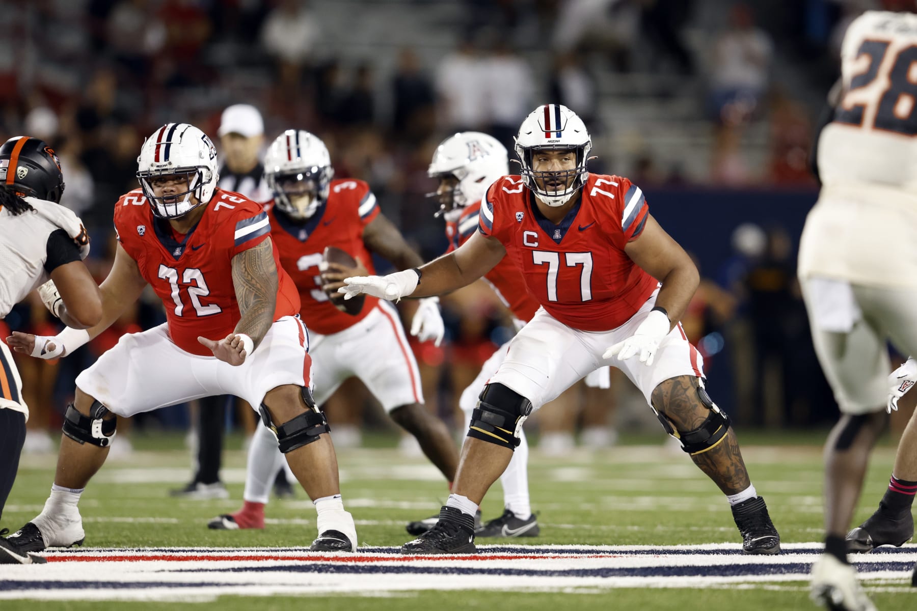 TUCSON, ARIZONA - OCTOBER 28: Offensive linemen Jordan Morgan #77 and Wendell Moe #72 of the Arizona Wildcats in action during the game against the Oregon State Beavers at Arizona Stadium on October 28, 2023 in Tucson, Arizona. The Wildcats defeated the Beavers 27-24. (Photo by Chris Coduto/Getty Images)