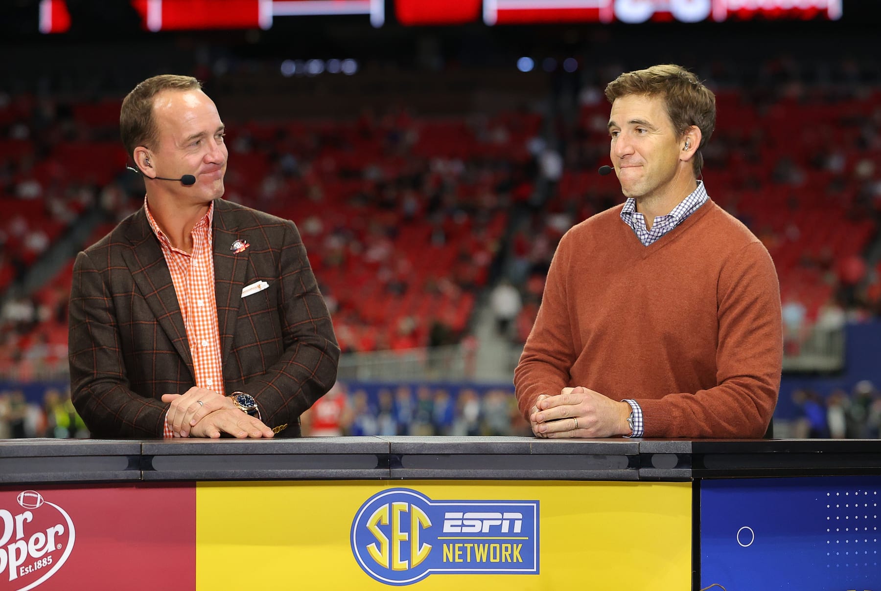 ATLANTA, GEORGIA - DECEMBER 03:  (L-R) Former Football Quarterbacks Peyton Manning and Eli Manning talk prior to the SEC Championship game between the LSU Tigers and the Georgia Bulldogs at Mercedes-Benz Stadium on December 03, 2022 in Atlanta, Georgia. (Photo by Kevin C. Cox/Getty Images)