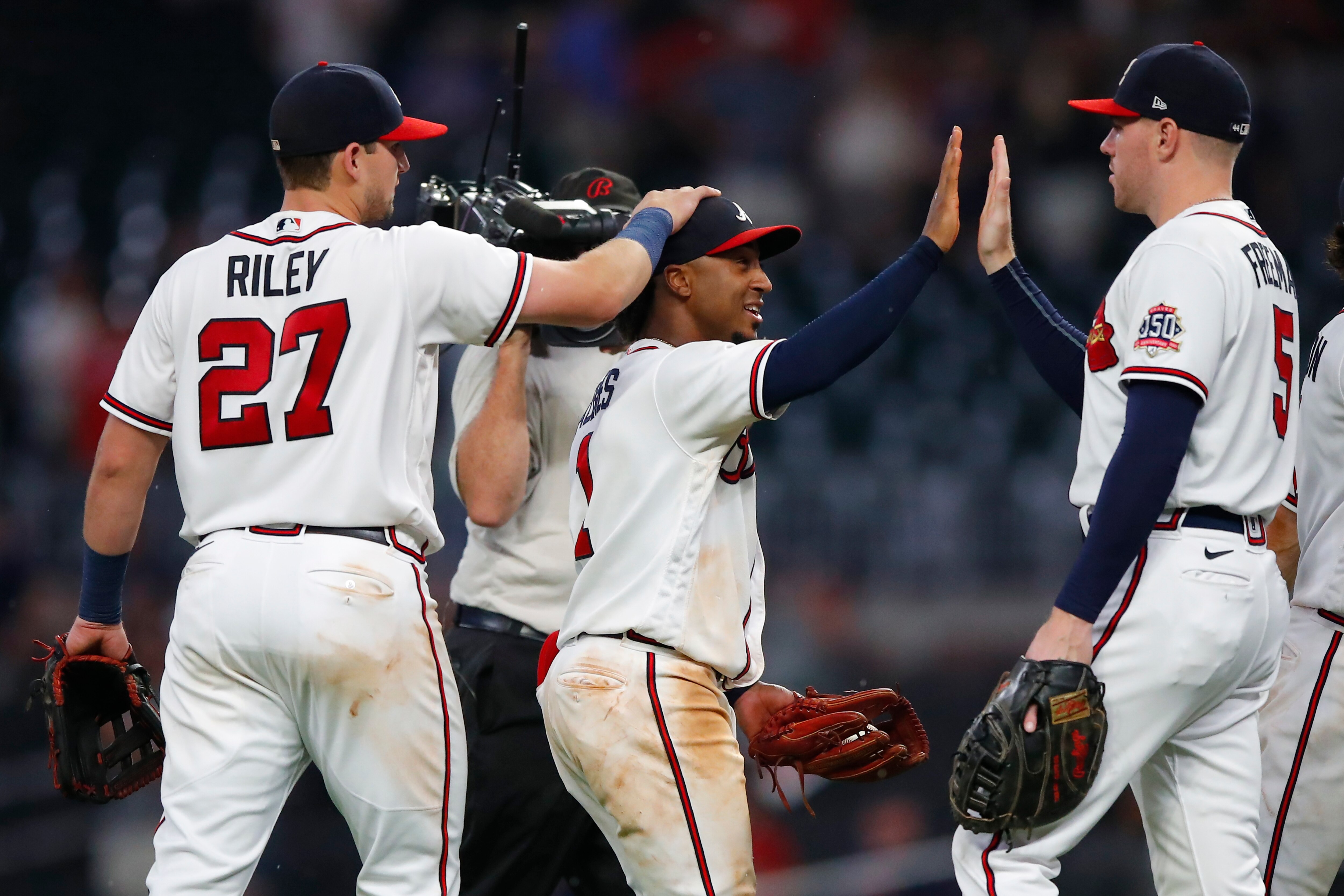 ATLANTA, GA - SEPTEMBER 07: Ozzie Albies #1 celebrates the 8-5 victory with Austin Riley #27 and Freddie Freeman #5 of the Atlanta Braves at the conclusion of an MLB game against the Washington Nationals at Truist Park on September 7, 2021 in Atlanta, Georgia. (Photo by Todd Kirkland/Getty Images)