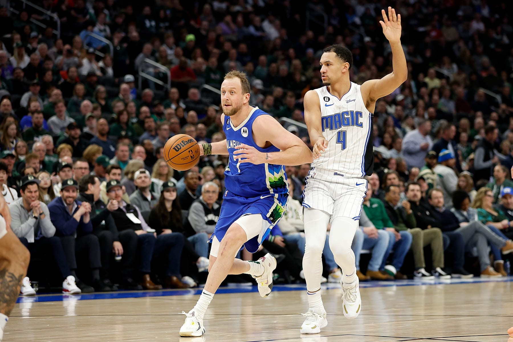 MILWAUKEE, WISCONSIN - MARCH 01: Joe Ingles #7 of the Milwaukee Bucks drives to the basket past Jalen Suggs #4 of the Orlando Magic during the first half of the game at Fiserv Forum on March 01, 2023 in Milwaukee, Wisconsin. NOTE TO USER: User expressly acknowledges and agrees that, by downloading and or using this photograph, User is consenting to the terms and conditions of the Getty Images License Agreement. (Photo by John Fisher/Getty Images)