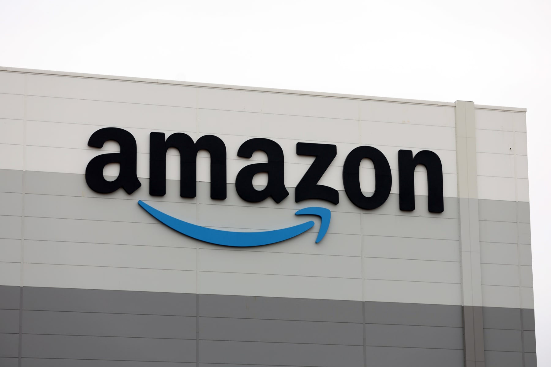 SUTTON COLDFIELD, ENGLAND - DECEMBER 19:  An Amazon logo is displayed outside the Amazon's Robotic Fulfillment Centre on December 19, 2023 in Sutton Coldfield, England. Launched in October, the 24/7 fulfillment center, equipped with cutting-edge robotics for sorting, packing, and shipping millions of items, has already employed 1,400 staff, as well as additional hires for the Christmas period. (Photo by Nathan Stirk/Getty Images)