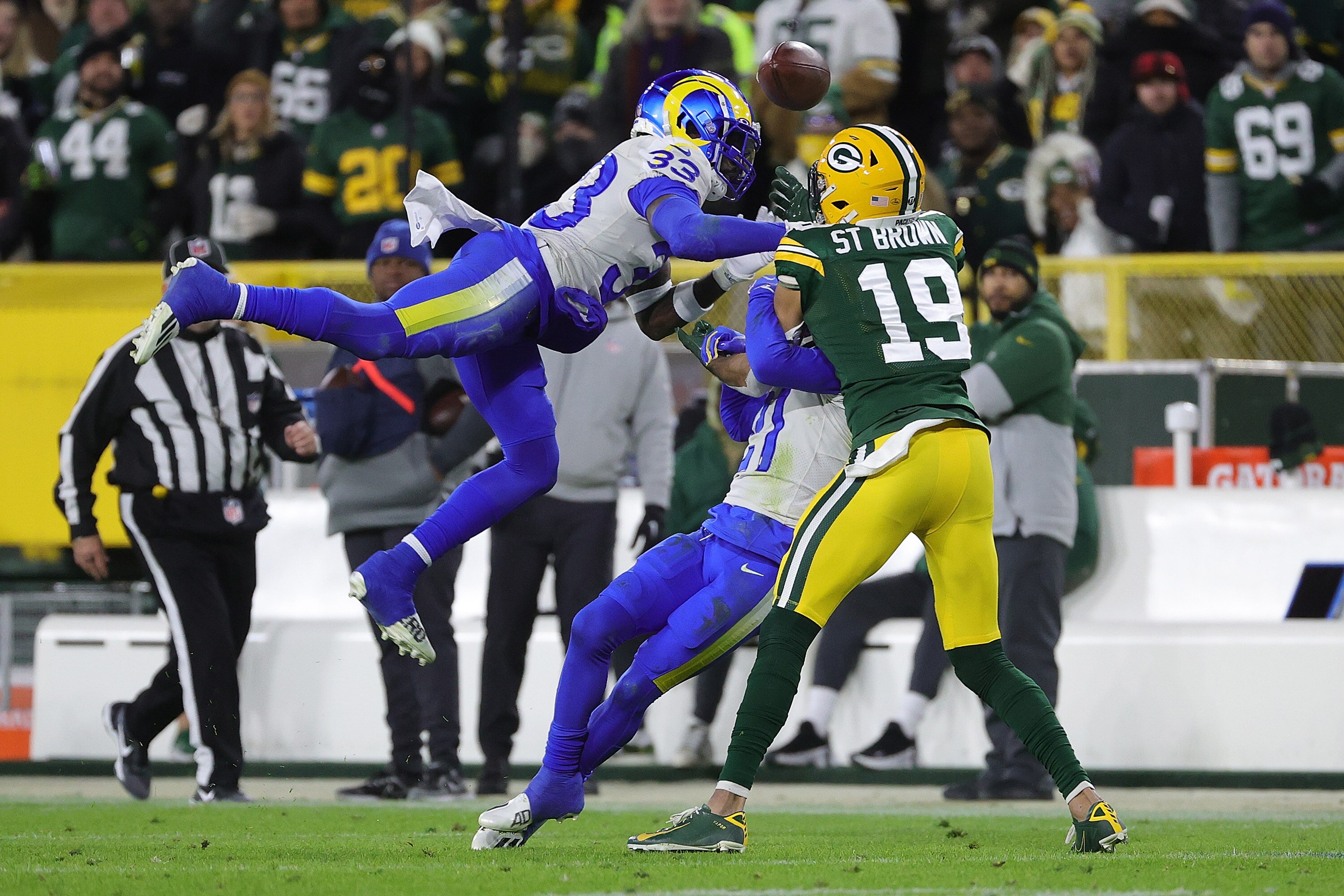GREEN BAY, WISCONSIN - NOVEMBER 28: Nick Scott #33 and Donte' Deayon #21 of the Los Angeles Rams defend a pass intended for Equanimeous St. Brown #19 of the Green Bay Packers during a game at Lambeau Field on November 28, 2021 in Green Bay, Wisconsin.  The Packers defeated the Rams 36-28.   (Photo by Stacy Revere/Getty Images)