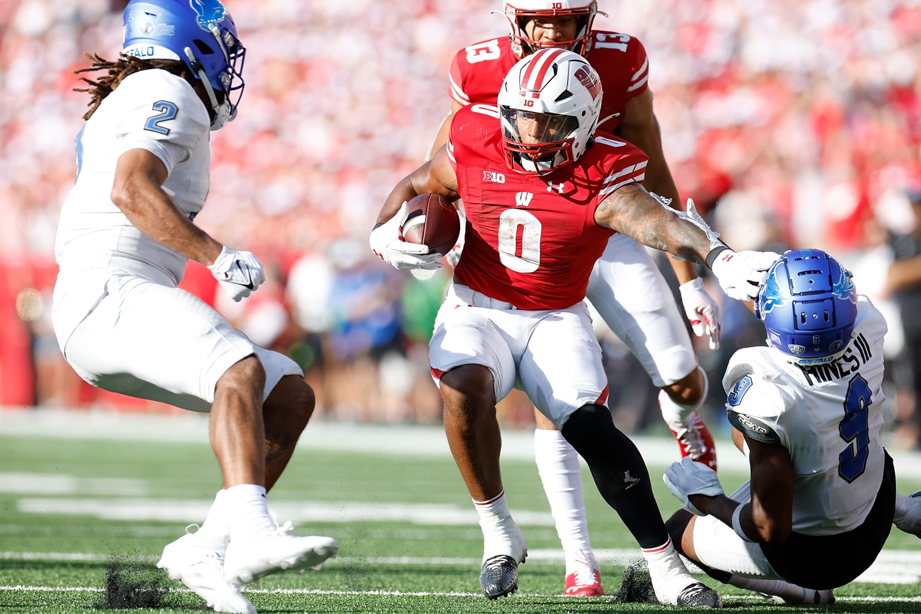 MADISON, WISCONSIN - SEPTEMBER 02: Braelon Allen #0 of the Wisconsin Badgers stiff arms Clevester Hines III #9 of the Buffalo Bulls on a 37 yard run in the third quarter against the Buffalo Bulls at Camp Randall Stadium on September 02, 2023 in Madison, Wisconsin. (Photo by John Fisher/Getty Images)