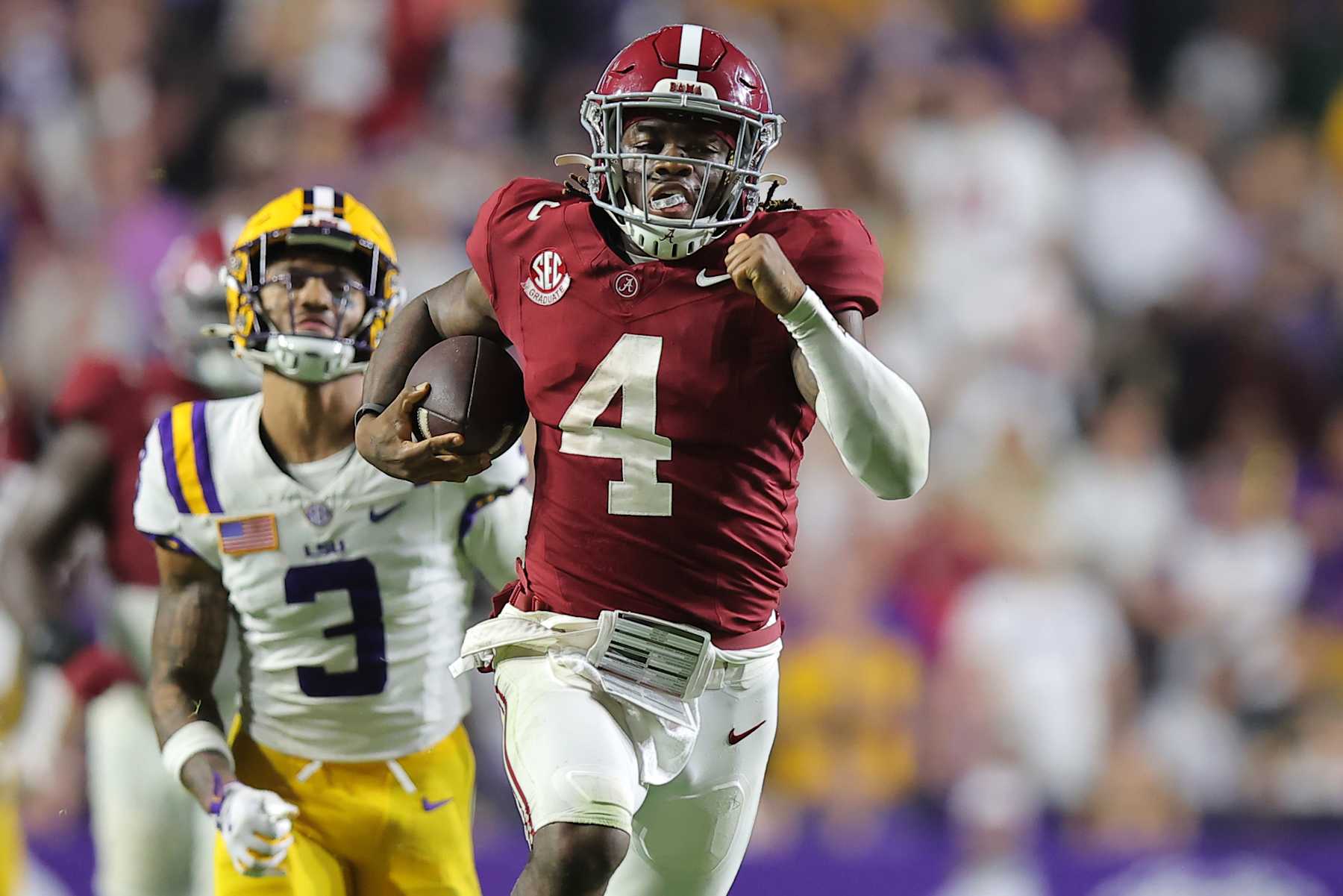 BATON ROUGE, LOUISIANA - NOVEMBER 09: Jalen Milroe #4 of the Alabama Crimson Tide rushes for a touchdown as Sage Ryan #3 of the LSU Tigers defends during the second half at Tiger Stadium on November 09, 2024 in Baton Rouge, Louisiana. (Photo by Jonathan Bachman/Getty Images)