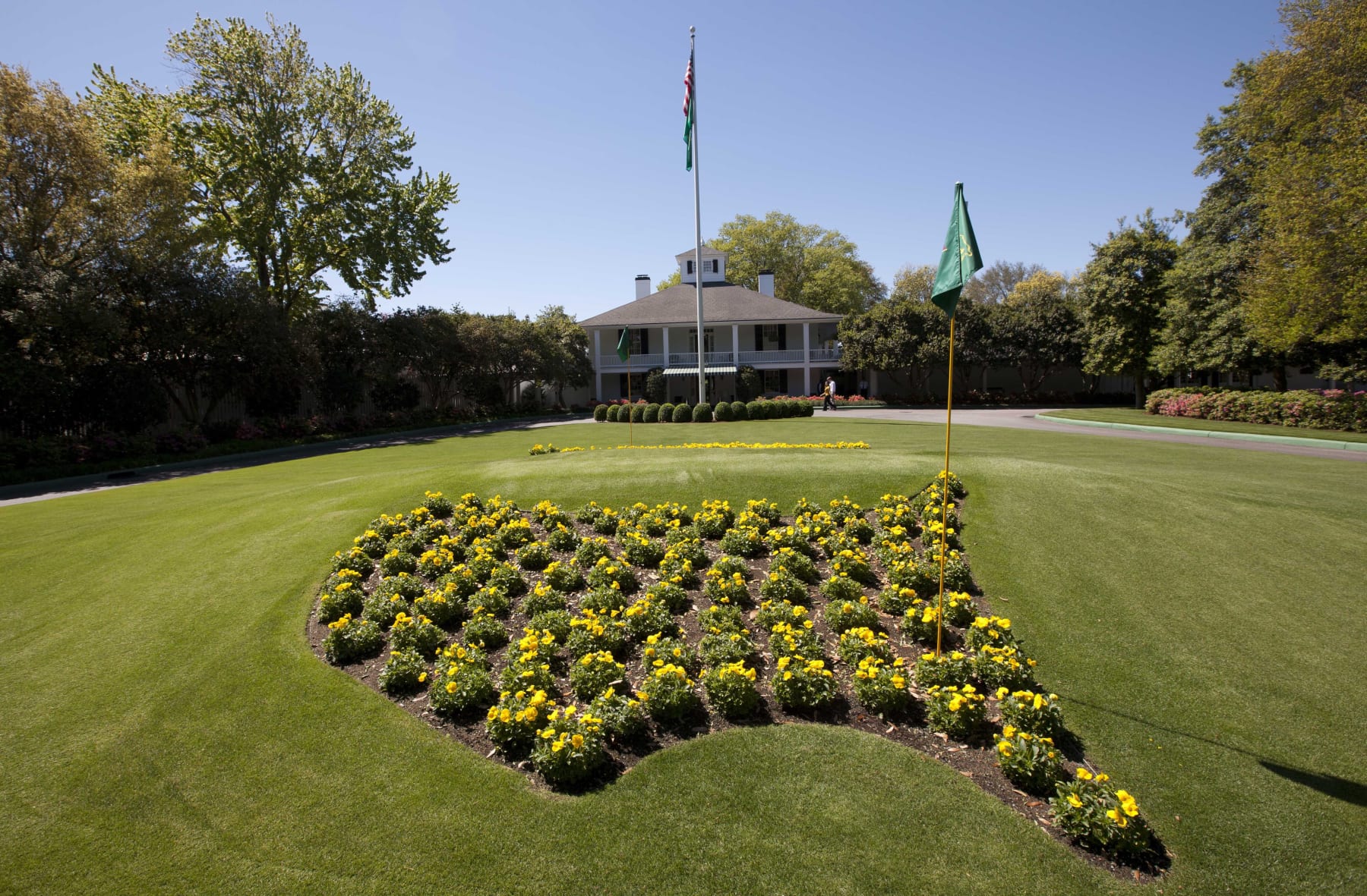 FILE - Flowers grace the entrance to the clubhouse at the Augusta National Golf Club as preparations continue for the Masters golf tournament in Augusta, Ga., on Sunday, April 3, 2011. The Masters starts Thursday, April 7, 2022 and the course at Augusta National is among the most famous in the world because it hosts the only major held in the same place. Most memorable is the back nine because of the two par-5 holes that can be reached in two. (AP Photo/Dave Martin, File)