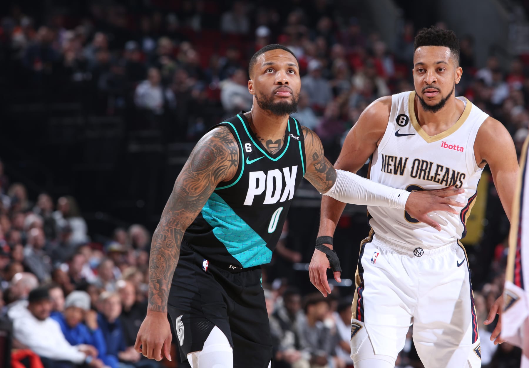 PORTLAND, OR - MARCH 1:  Damian Lillard #0 of the Portland Trail Blazers and CJ McCollum #3 of the New Orleans Pelicans looks on during the game on March 1, 2023 at the Moda Center Arena in Portland, Oregon. NOTE TO USER: User expressly acknowledges and agrees that, by downloading and or using this photograph, user is consenting to the terms and conditions of the Getty Images License Agreement. Mandatory Copyright Notice: Copyright 2023 NBAE (Photo by Sam Forencich/NBAE via Getty Images)