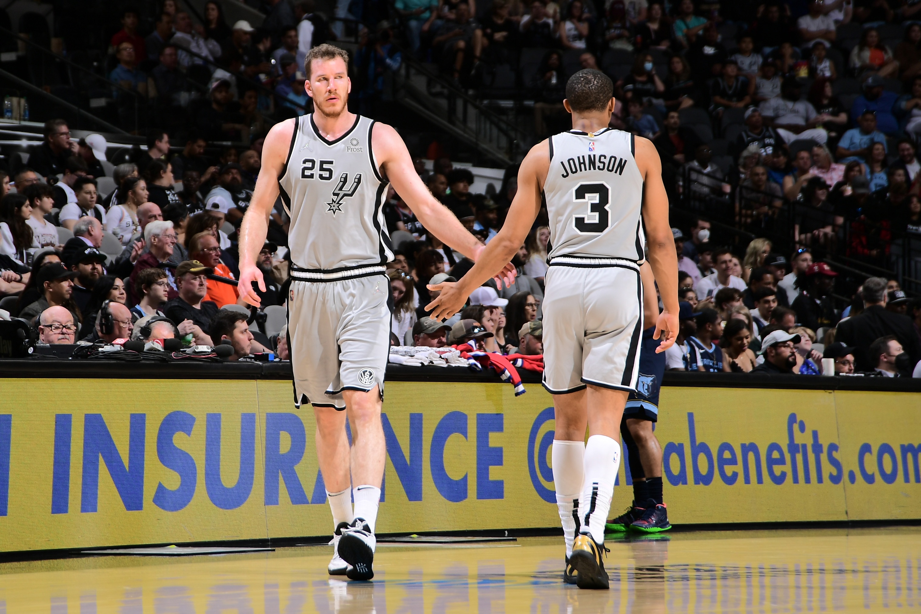 SAN ANTONIO, TX - MARCH 30: Jakob Poeltl #25 hi-fives Keldon Johnson #3 of the San Antonio Spurs during the game against the Memphis Grizzlies on March 30, 2022 at the AT&T Center in San Antonio, Texas. NOTE TO USER: User expressly acknowledges and agrees that, by downloading and or using this photograph, user is consenting to the terms and conditions of the Getty Images License Agreement. Mandatory Copyright Notice: Copyright 2022 NBAE (Photos by Michael Gonzales/NBAE via Getty Images)
