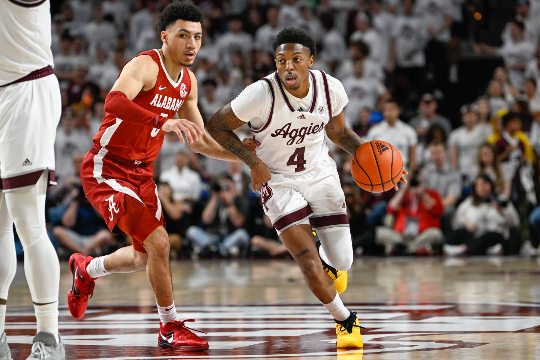 COLLEGE STATION, TX - MARCH 04: Texas A&M Aggies guard Wade Taylor IV (4) drives as Alabama Crimson Tide guard Jahvon Quinerly (5) defends during the basketball game between the Alabama Crimson Tide and Texas A&M Aggies at Reed Arena on March 4, 2023 in College Station, Texas. (Photo by Ken Murray/Icon Sportswire via Getty Images)