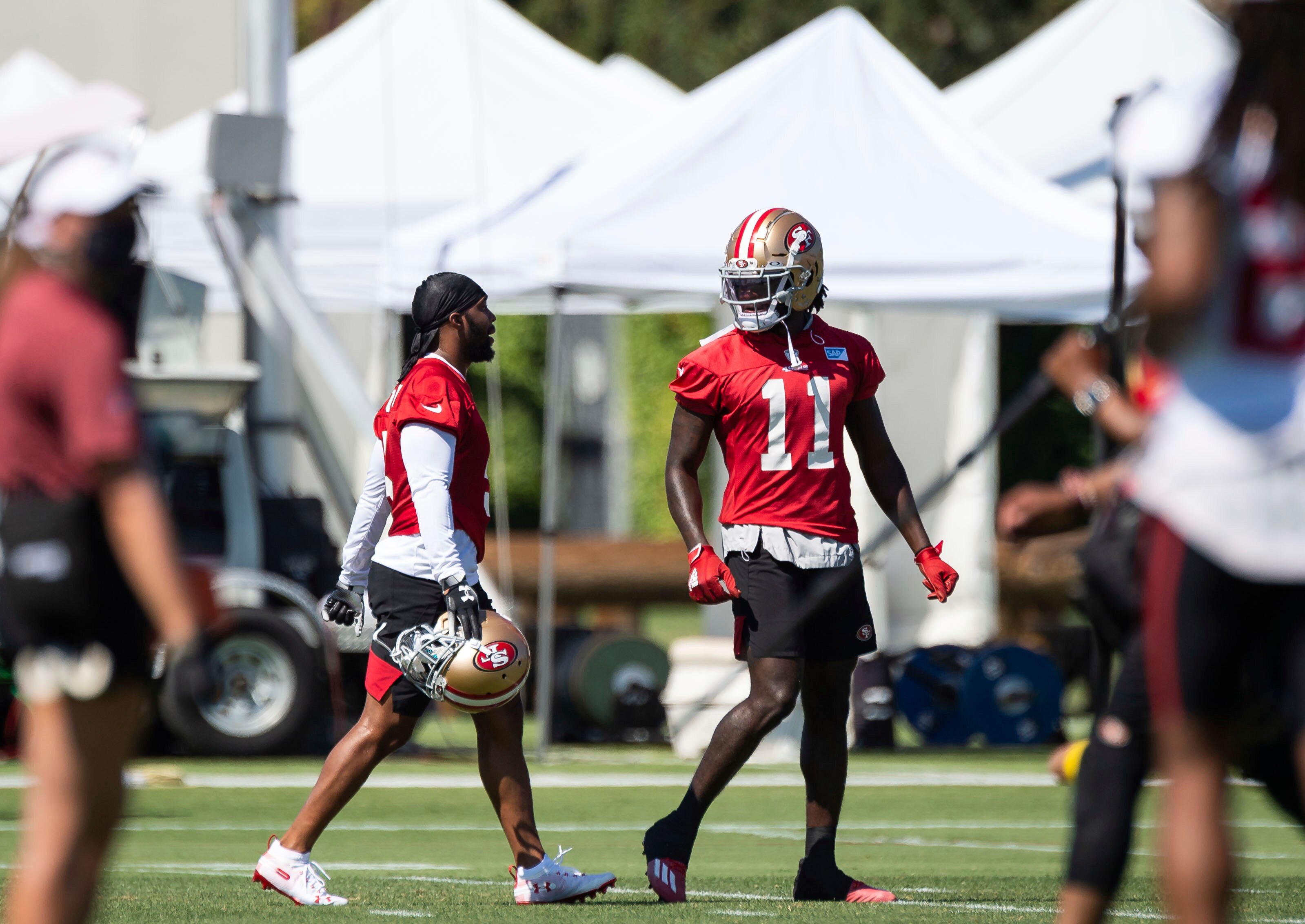 San Francisco 49ers wide receiver Brandon Aiyuk (11), right, turns back to talk with Tavon Austin (5) during NFL Training Camp practice Saturday, Aug. 15, 2020, at the SAP Performance Facility in Santa Clara, Calif. (Xavier Mascarenas/The Sacramento Bee via AP)