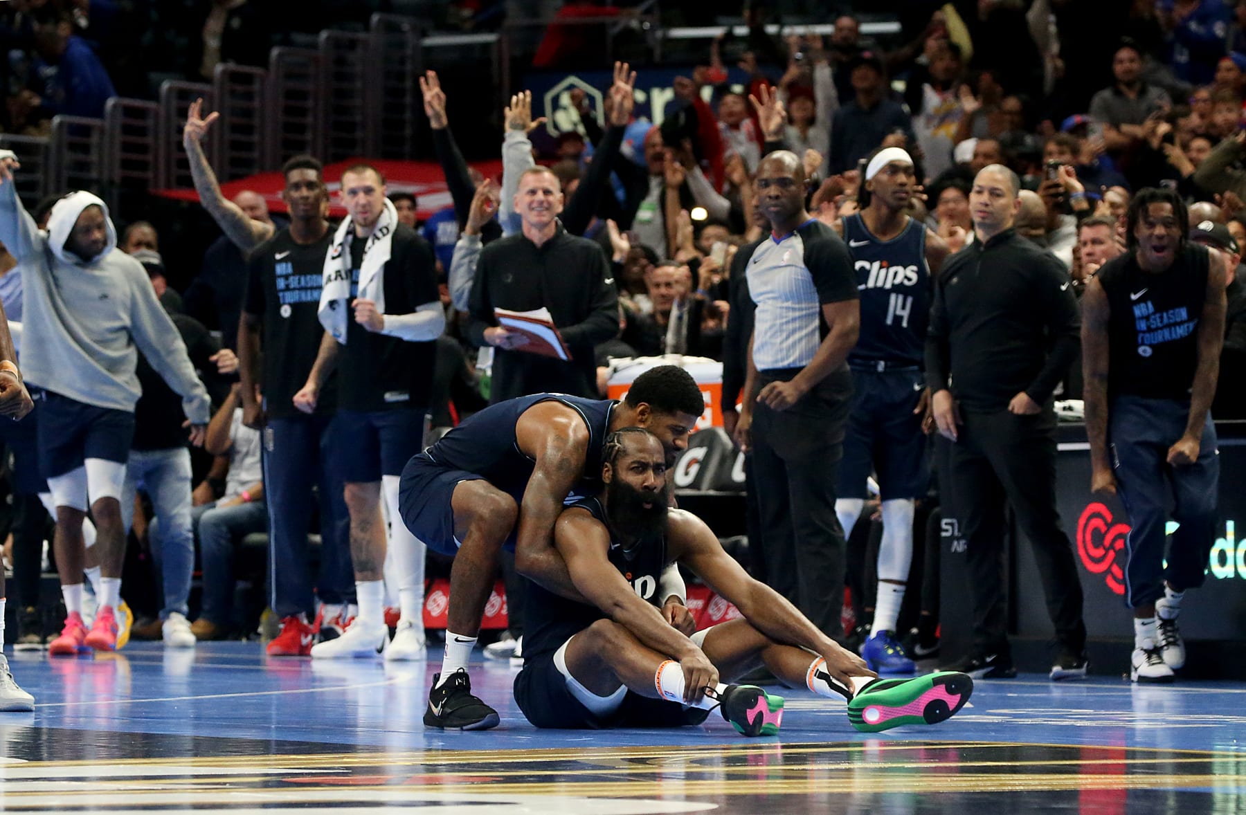 Los Angeles, CA -  Clippers forward Paul George picks up teammate  James Harden was knocked down hitting a three-pointer late in the second half to seal a 106-100 victory for over the Houston Rockets  at crypto.com Arena in Los Angeles on Friday night, Nov. 17, 2023. (Luis Sinco / Los Angeles Times via Getty Images)