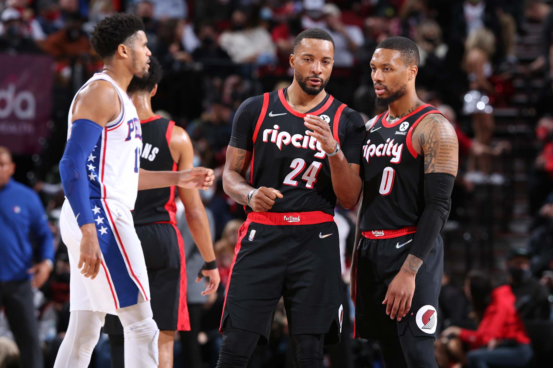 PORTLAND, OR - NOVEMBER 20: Damian Lillard #0 and Norman Powell #24 of the Portland Trail Blazers talk during the game against the Philadelphia 76ers  on November 20, 2021 at the Moda Center Arena in Portland, Oregon. NOTE TO USER: User expressly acknowledges and agrees that, by downloading and or using this photograph, user is consenting to the terms and conditions of the Getty Images License Agreement. Mandatory Copyright Notice: Copyright 2021 NBAE (Photo by Sam Forencich/NBAE via Getty Images)