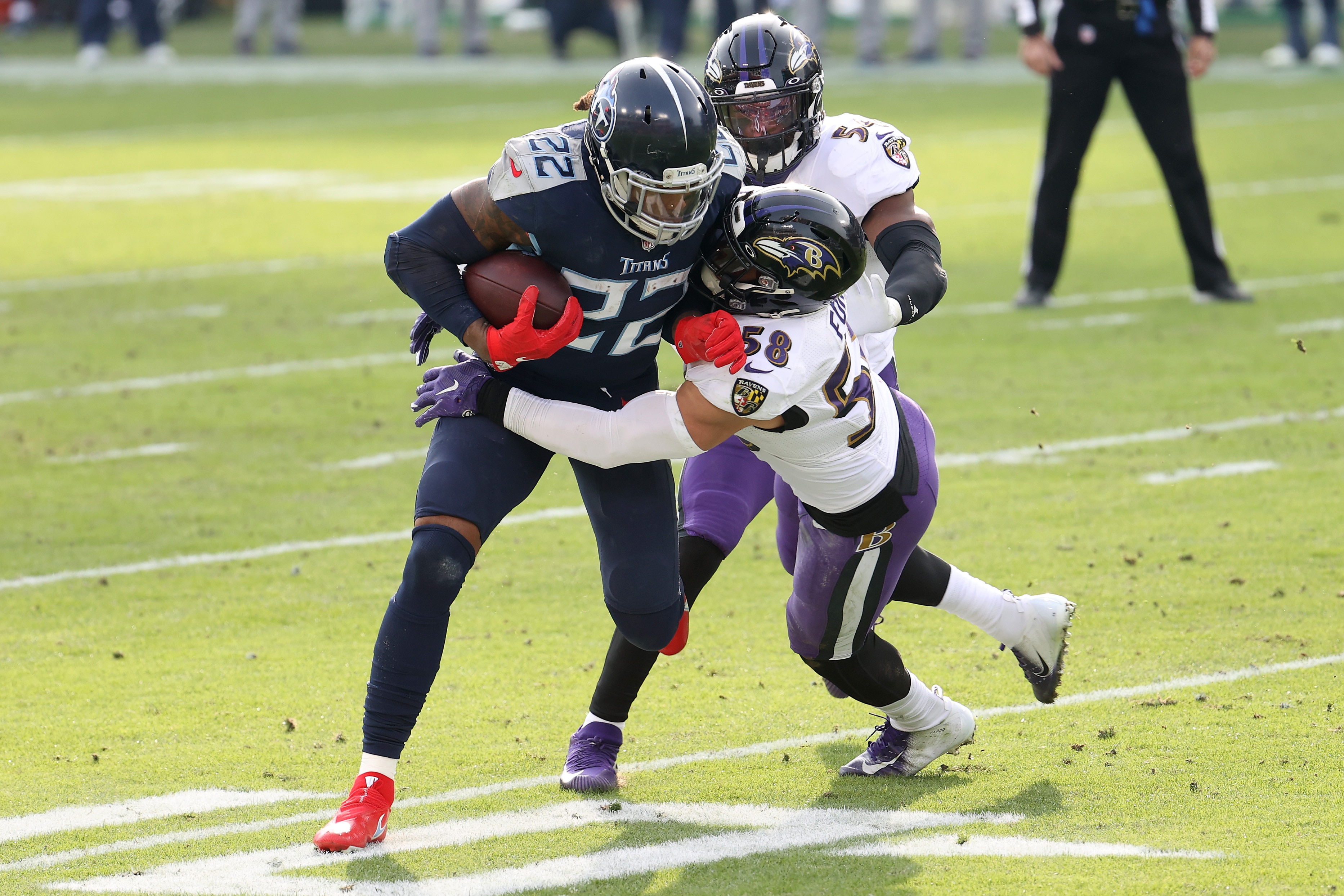 NASHVILLE, TENNESSEE - JANUARY 10: Running back Derrick Henry #22 of the Tennessee Titans attempts to break a tackle from linebacker L.J. Fort #58 of the Baltimore Ravens during the fourth quarter of their AFC Wild Card Playoff game at Nissan Stadium on January 10, 2021 in Nashville, Tennessee. (Photo by Andy Lyons/Getty Images)