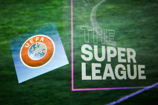 UEFA logo displayed on a phone screen and The Super League logo displayed on a screen are seen in this multiple exposure illustration photo taken in Krakow, Poland on April 20, 2021. (Photo Illustration by Jakub Porzycki/NurPhoto via Getty Images)