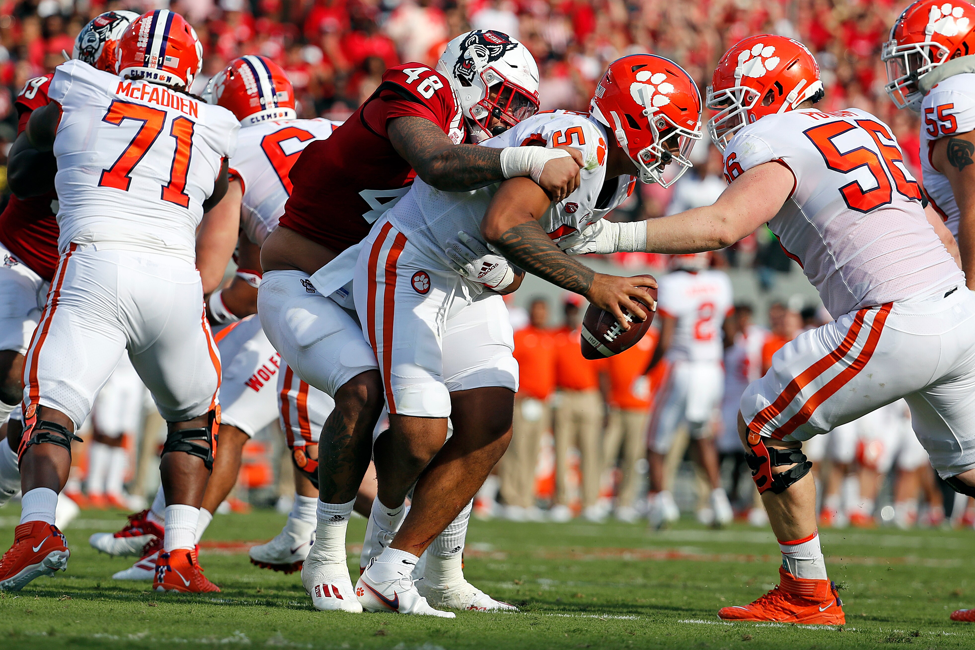 North Carolina State's Cory Durden (48) grabs a hold of Clemson's D.J. Uiagalelei (5) for a sack during the first half of an NCAA college football game in Raleigh, N.C., Saturday, Sept. 25, 2021. (AP Photo/Karl B DeBlaker)