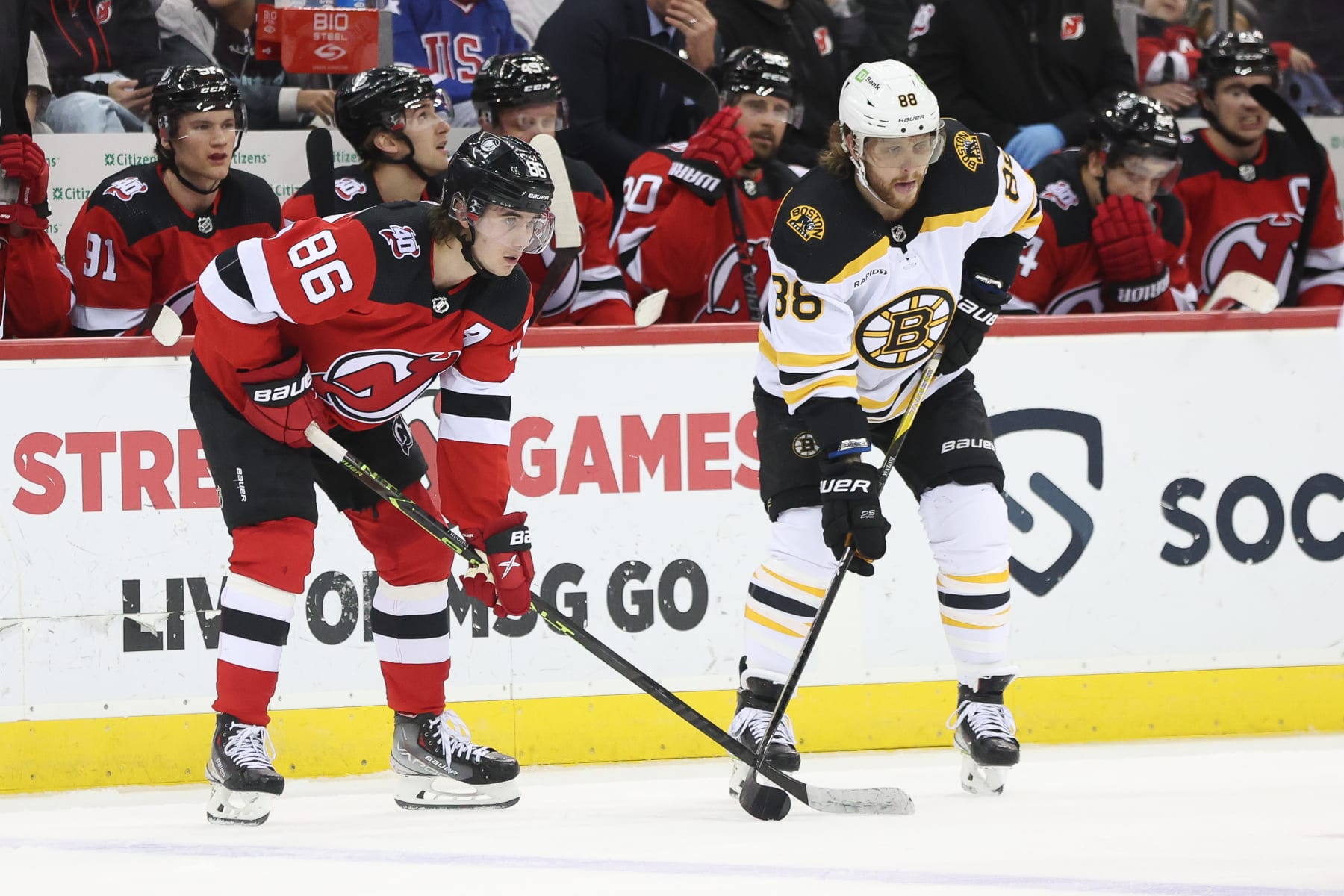 NEWARK, NJ - DECEMBER 28: New Jersey Devils center Jack Hughes (86) and Boston Bruins right wing David Pastrnak (88) await a face-off during the National Hockey League game between the Boston Bruins and the New Jersey Devils on December 28, 2022 at Prudential Center in Newark, NJ. (Photo by Andrew Mordzynski/Icon Sportswire via Getty Images)