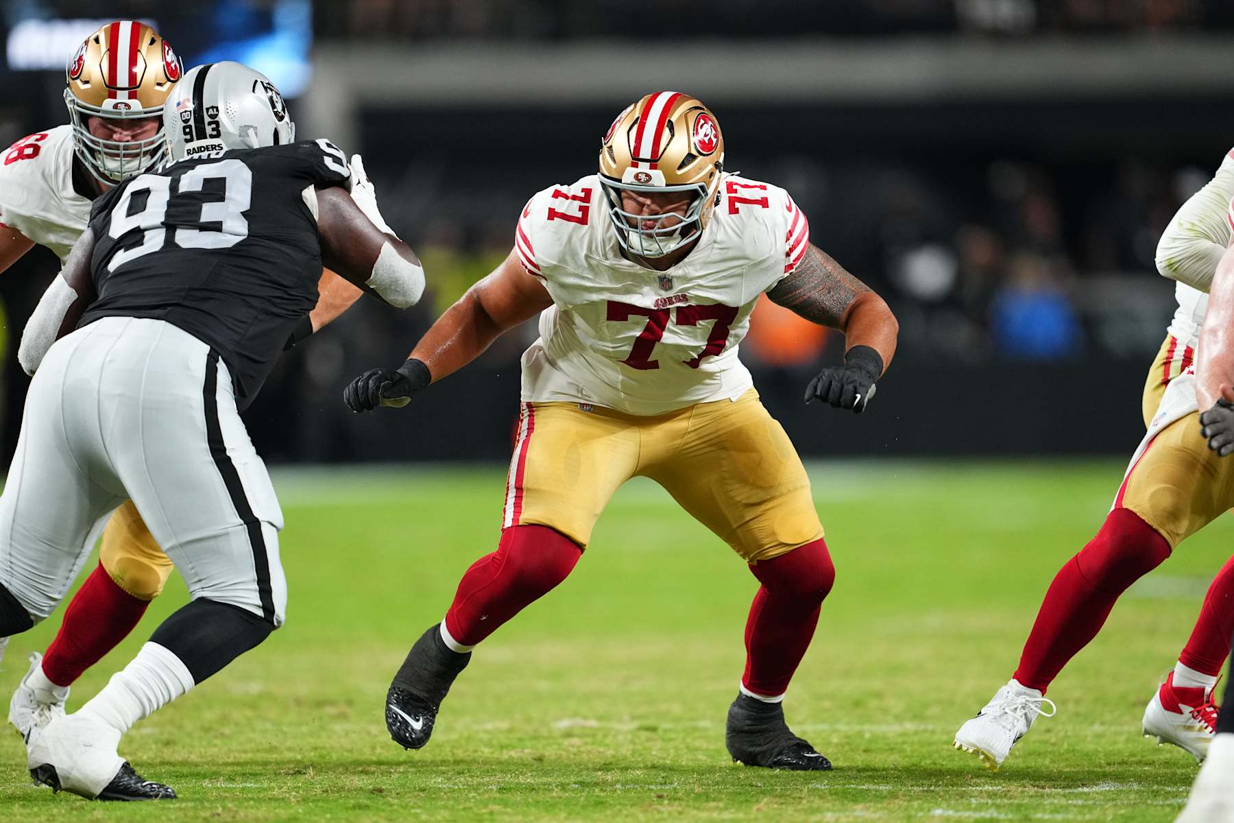 LAS VEGAS, NEVADA - AUGUST 23:  Guard Dominick Puni #77 of the San Francisco 49ers looks to block against the Las Vegas Raiders during the first half of a preseason game at Allegiant Stadium on August 23, 2024 in Las Vegas, Nevada. (Photo by Chris Unger/Getty Images)