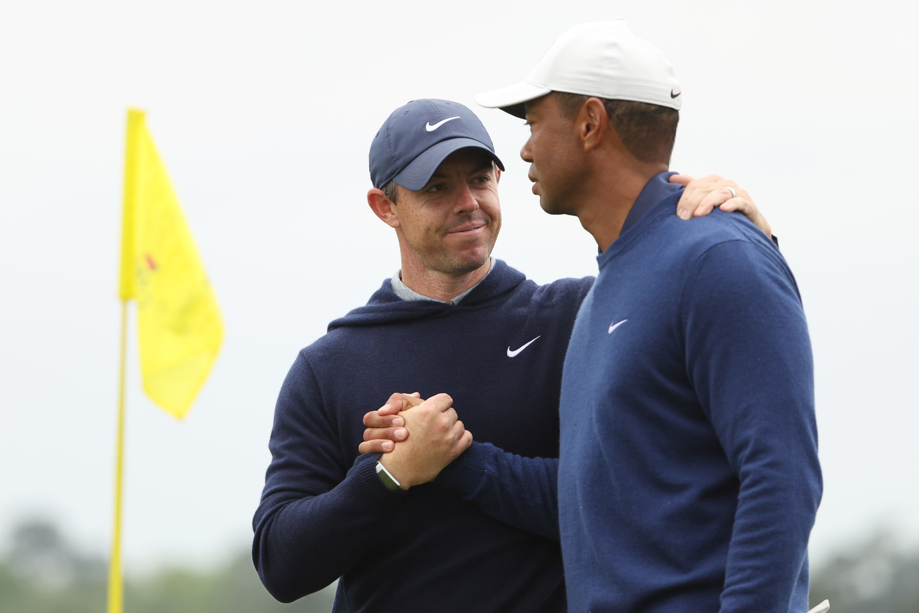 AUGUSTA, GEORGIA - APRIL 03: Rory McIlroy of Northern Ireland shakes hands with Tiger Woods of the United States on the 18th green after they completed a practice round prior to the 2023 Masters Tournament at Augusta National Golf Club on April 03, 2023 in Augusta, Georgia. (Photo by Christian Petersen/Getty Images)