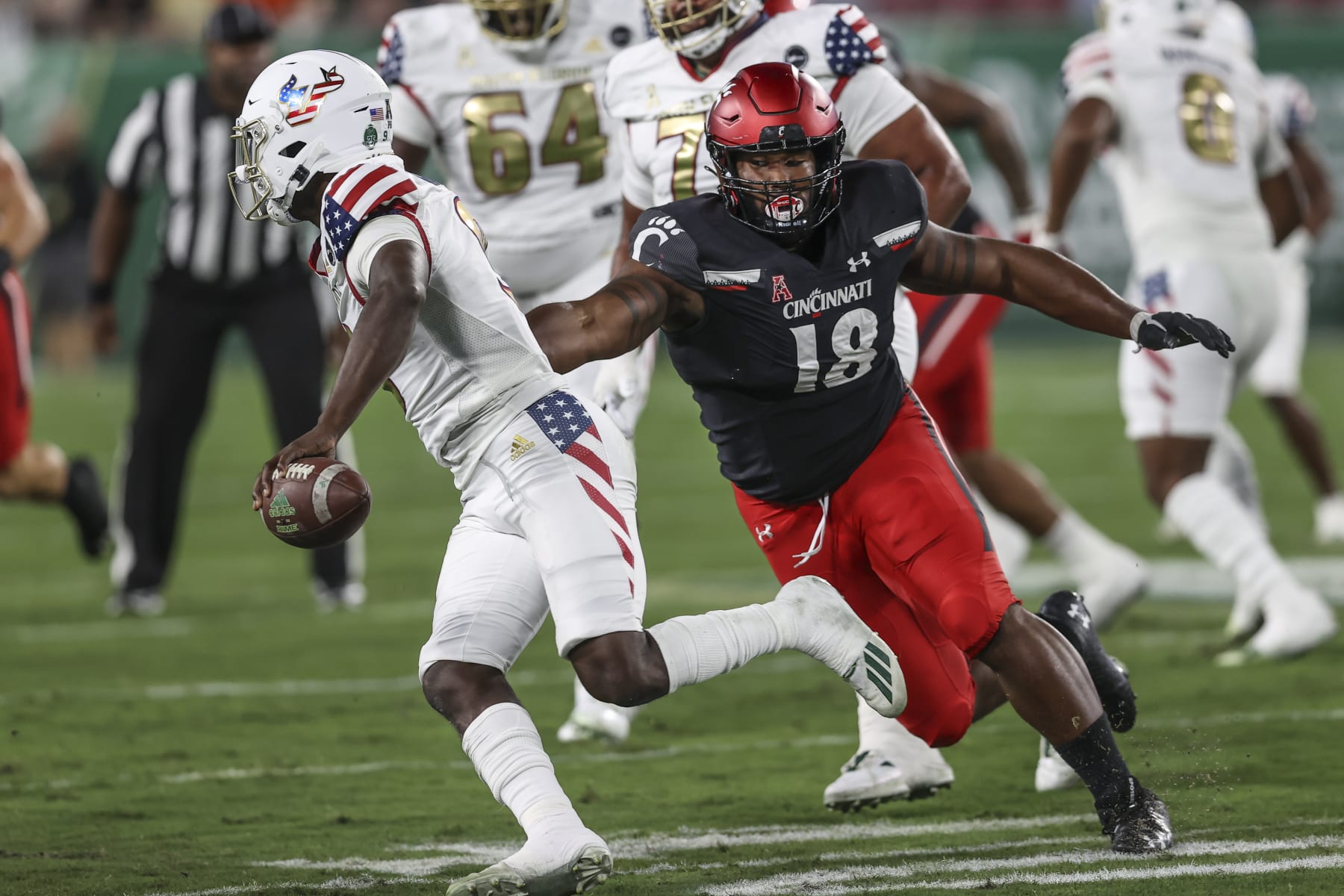 TAMPA, FL - NOVEMBER 12: Cincinnati Bearcats defensive lineman Jowon Briggs (18) puts pressure on South Florida Bulls quarterback Timmy McClain (9) during the college football game between the Cincinnati Bearcats and South Florida Bulls on November  12, 2021 at Raymond James Stadium in Tampa, FL. (Photo by Mark LoMoglio/Icon Sportswire via Getty Images)