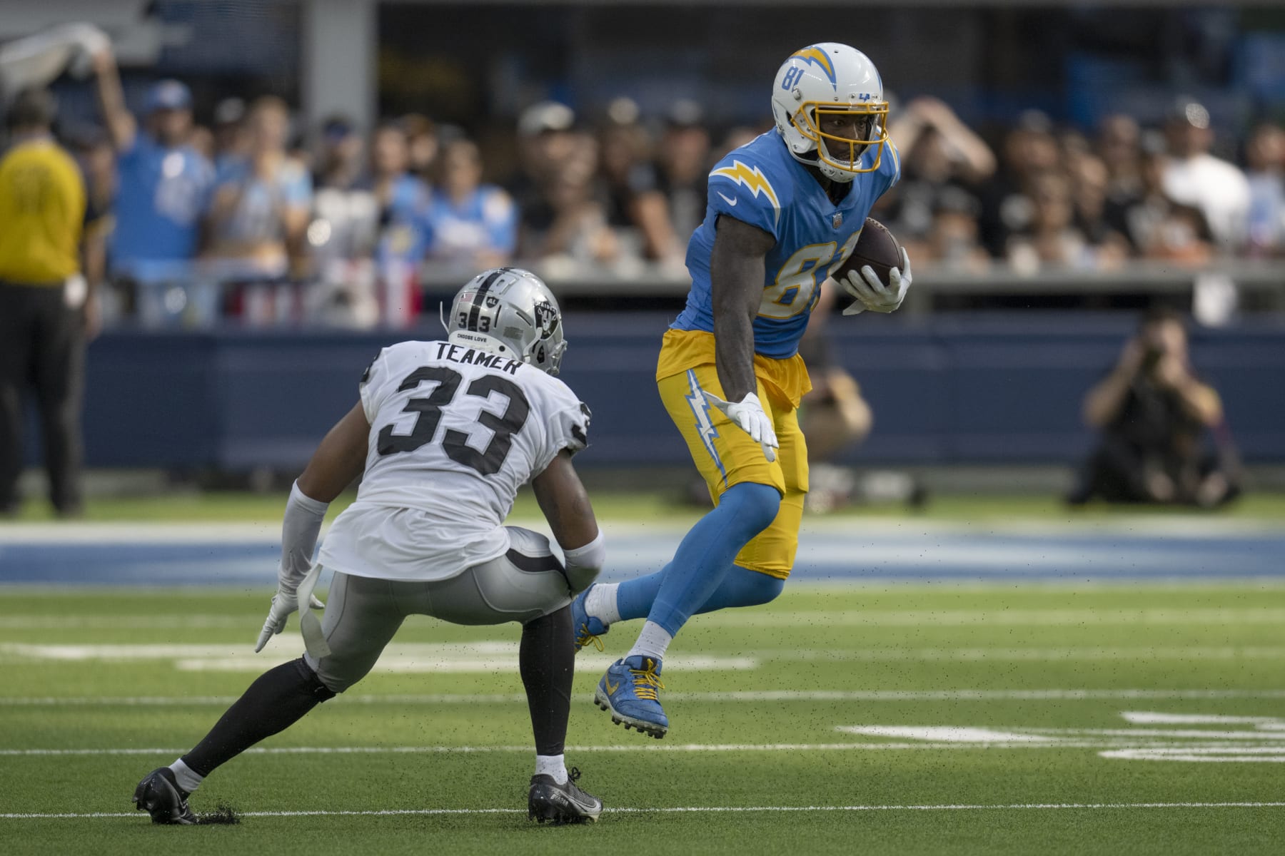 Los Angeles Chargers wide receiver Mike Williams (81) avoids a tackle by Las Vegas Raiders safety Roderic Teamer (33) in the second half during an NFL football game Thursday, Sept. 8, 2021, in Inglewood, Calif. (AP Photo/John McCoy)