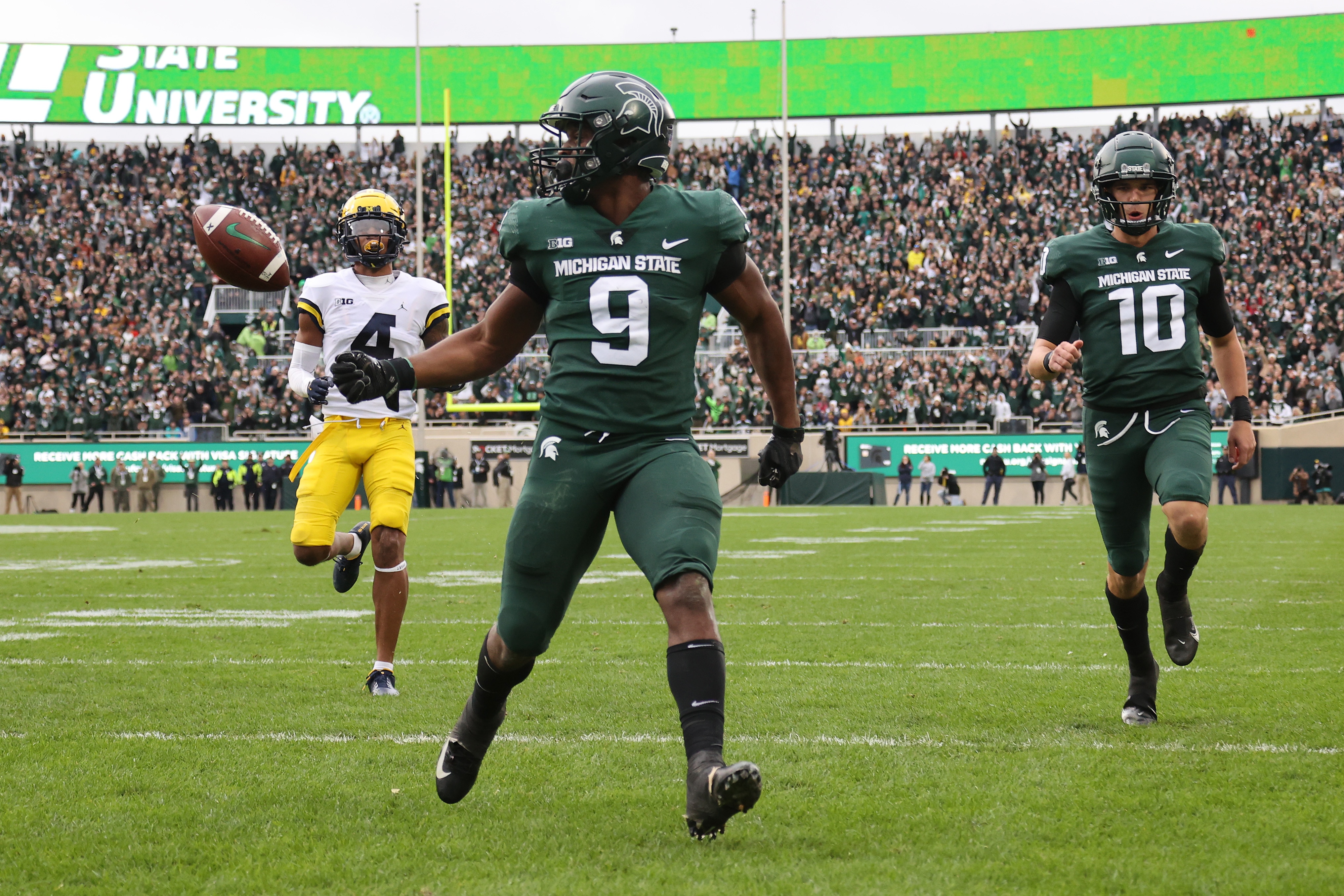 EAST LANSING, MICHIGAN - OCTOBER 30: Kenneth Walker III #9 of the Michigan State Spartans scores a first half touchdown in front of Vincent Gray #4 of the Michigan Wolverines at Spartan Stadium on October 30, 2021 in East Lansing, Michigan. (Photo by Gregory Shamus/Getty Images)