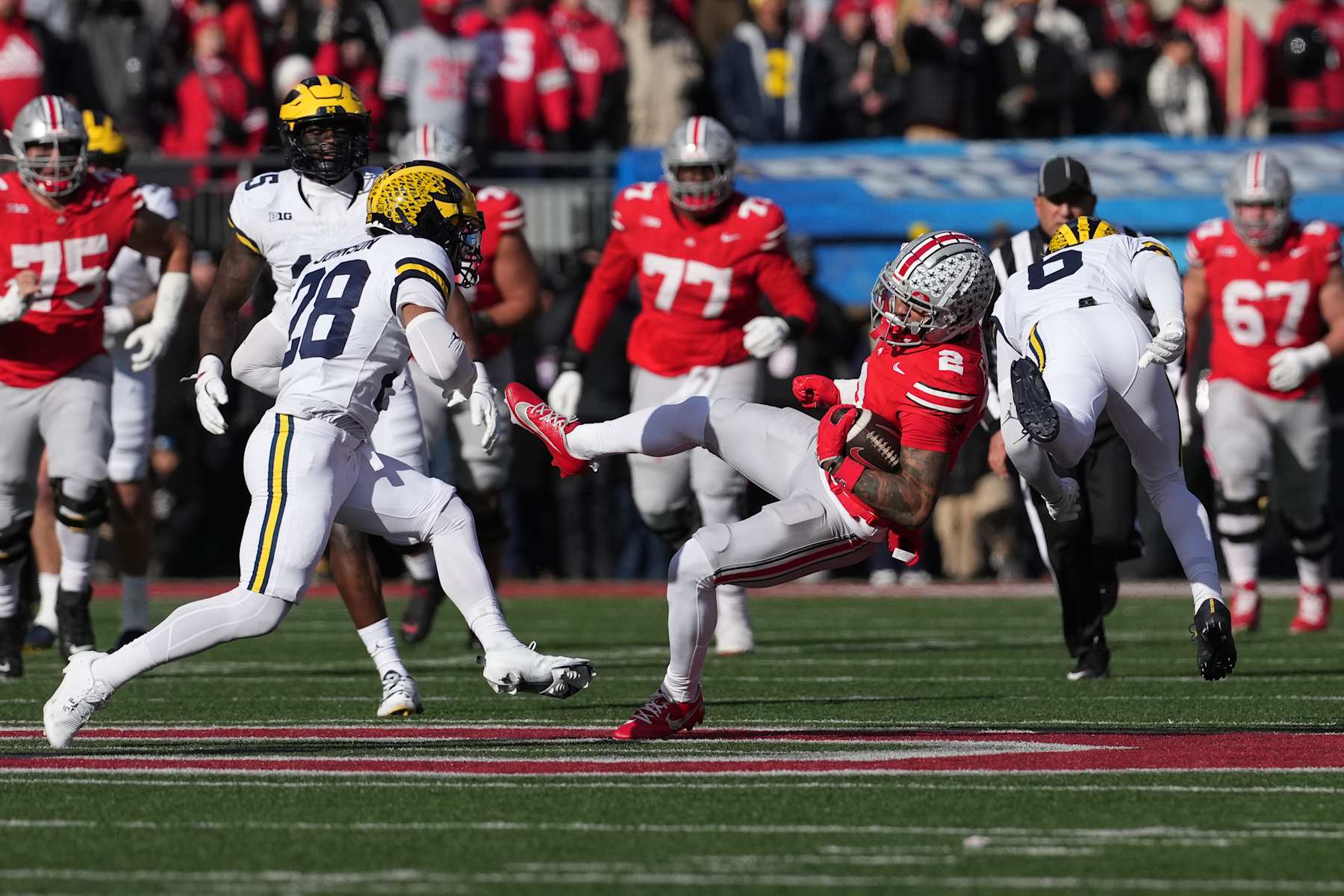COLUMBUS, OHIO - NOVEMBER 30: Emeka Egbuka #2 of the Ohio State Buckeyes is hit by Brandyn Hillman #6 of the Michigan Wolverines as Quinten Johnson #28 pursues during the second quarter at Ohio Stadium on November 30, 2024 in Columbus, Ohio. (Photo by Jason Mowry/Getty Images)