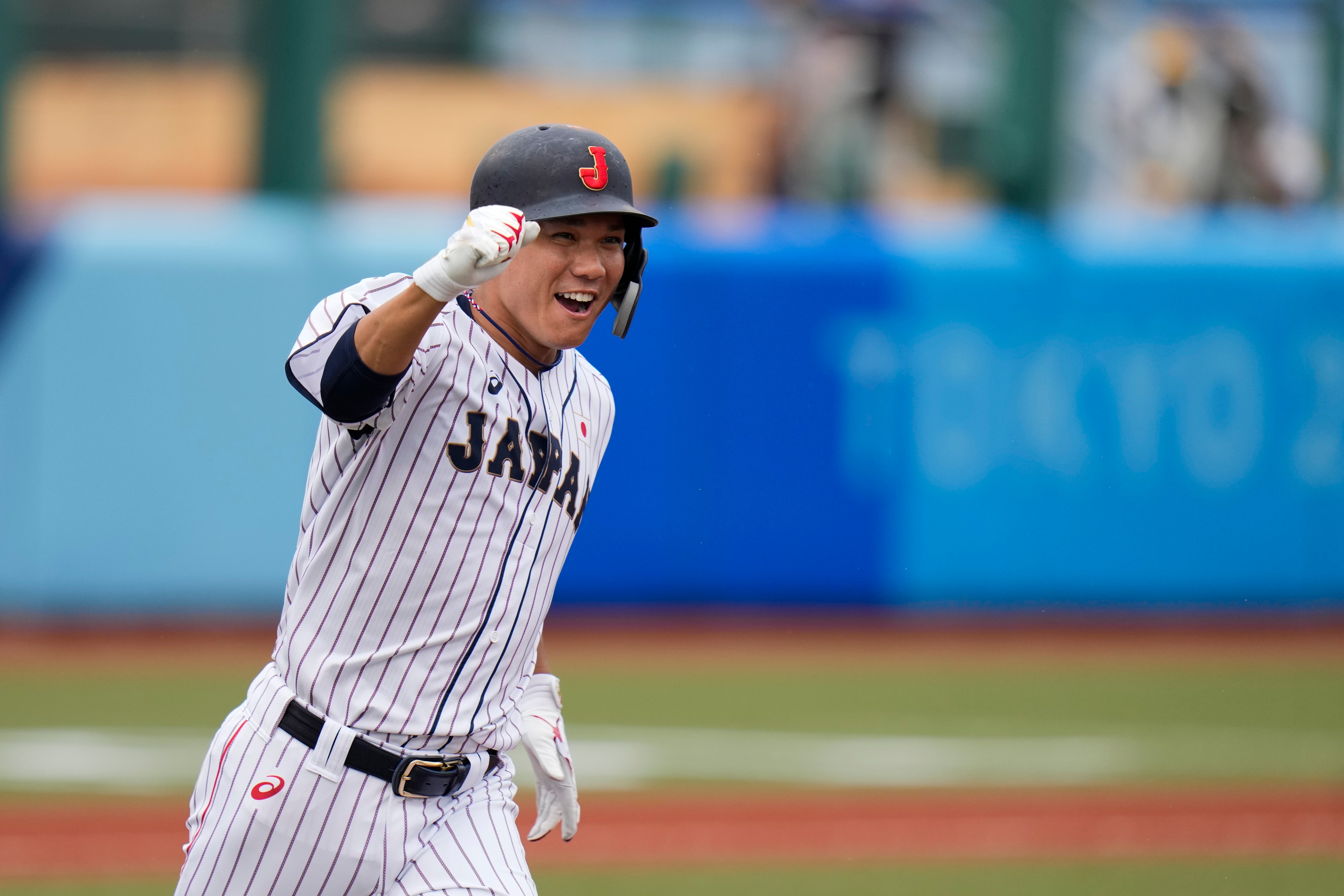 Japan's Hayato Sakamoto celebrates his walk-off single in the ninth inning of a baseball game against the Dominican Republic at the 2020 Summer Olympics, Wednesday, July 28, 2021, in Fukushima, Japan. Japan won 4-3. (AP Photo/Jae C. Hong)