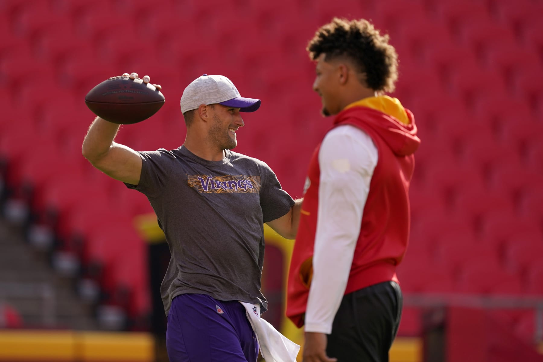 Minnesota Vikings quarterback Kirk Cousins, left, warms up alongside Kansas City Chiefs quarterback Patrick Mahomes before a preseason NFL football game Friday, Aug. 27, 2021, in Kansas City, Mo. (AP Photo/Charlie Riedel)