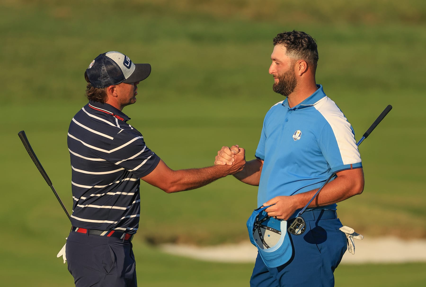 ROME, ITALY - SEPTEMBER 29: Jon Rahm of Spain and The European Team shakes hands with Brooks Koepka after he had holed a long eagle putt on the 18th hole to tie his match with Nicolia Hojgaard against Koepka and Scottie Scheffler of The United States Team during the Friday afternoon four-ball matches of the 2023 Ryder Cup at Marco Simone Golf Club on September 29, 2023 in Rome, Italy. (Photo by David Cannon/Getty Images)