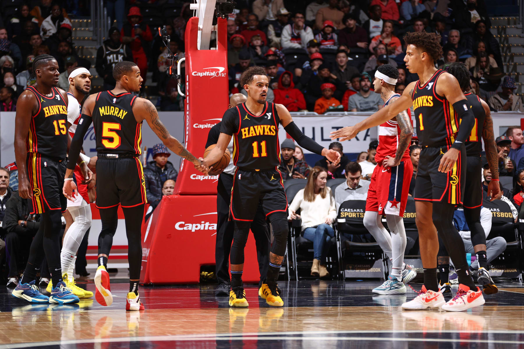 WASHINGTON, DC -  DECEMBER 31: Trae Young #11, Dejounte Murray #5 and Jalen Johnson #1 of the Atlanta Hawks high five during the game against the Washington Wizards on December 31, 2023 at Capital One Arena in Washington, DC. NOTE TO USER: User expressly acknowledges and agrees that, by downloading and or using this Photograph, user is consenting to the terms and conditions of the Getty Images License Agreement. Mandatory Copyright Notice: Copyright 2023 NBAE (Photo by Kenny Giarla/NBAE via Getty Images)