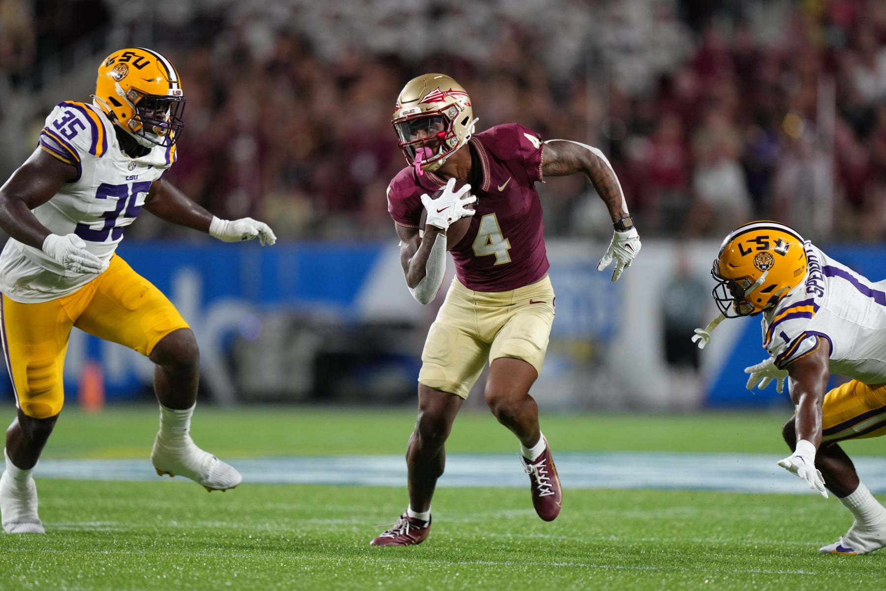 ORLANDO, FL - SEPTEMBER 03: Florida State Seminoles wide receiver Keon Coleman (4) runs after a catch as LSU Tigers linebacker Omar Speights (1) and LSU Tigers defensive end Sai'vion Jones (35) look to make the stop during the Camping World Kickoff game between the LSU Tigers and the Florida State Seminoles, on Sunday, September 3, 2023 at Camping World Stadium in Orlando, Fla. (Photo by Peter Joneleit/Icon Sportswire via Getty Images)