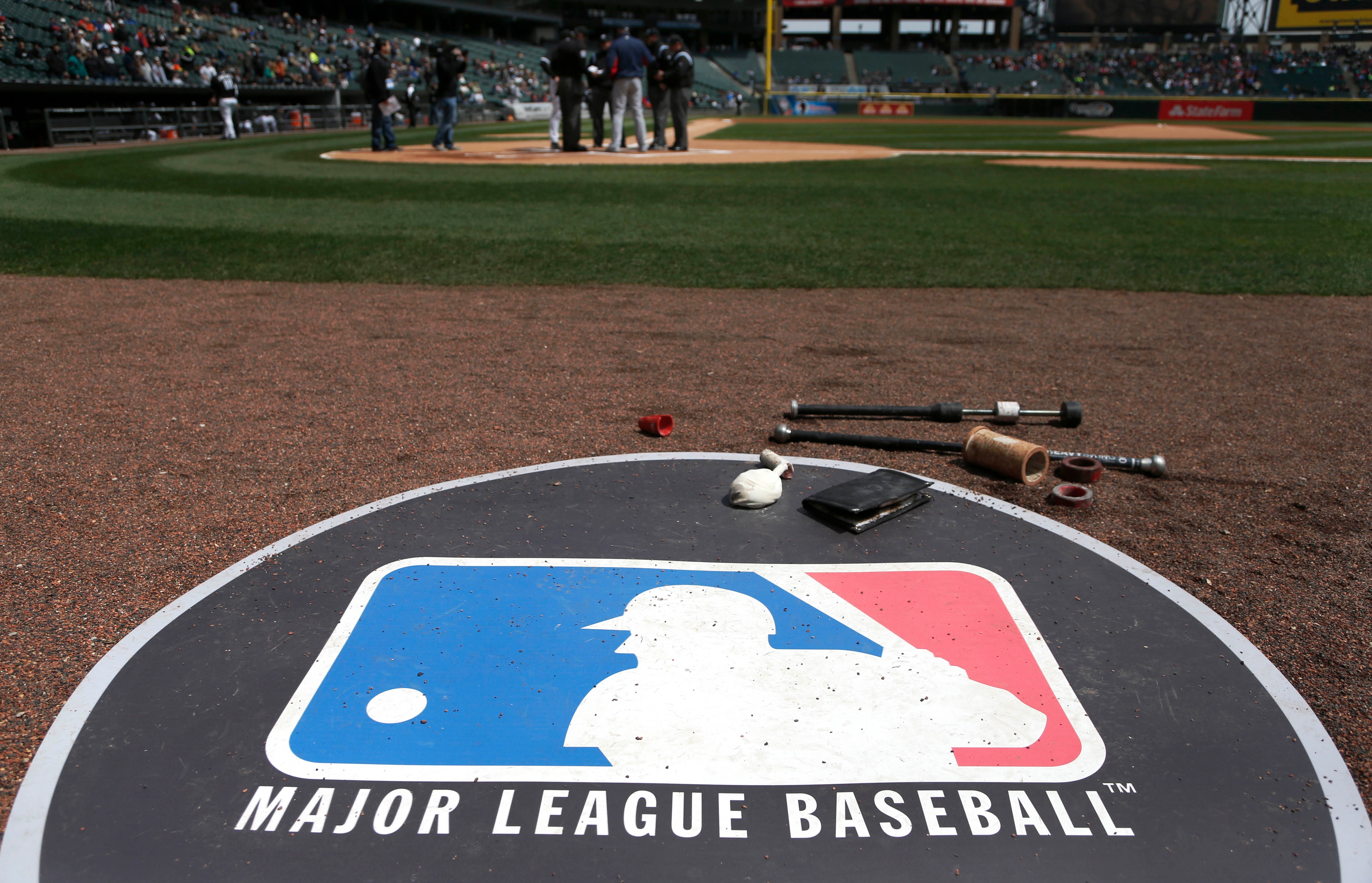 The Major League Baseball logo serves as the visitor's on deck circle before a baseball game between the Chicago White Sox and the Cleveland Indians Wednesday, April 24, 2013, in Chicago. (AP Photo/Charles Rex Arbogast)