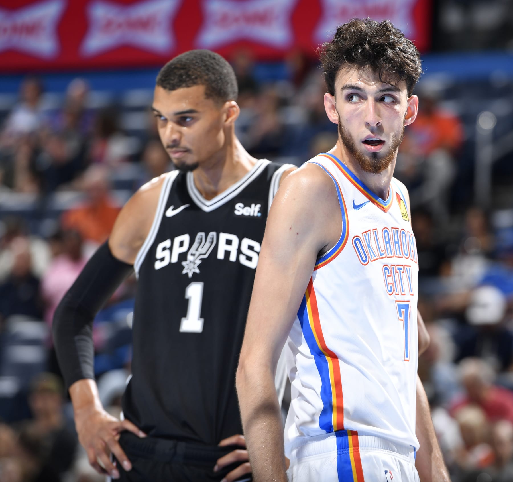 OKLAHOMA CITY, OK - OCTOBER 9: Chet Holmgren #7 of the Oklahoma City Thunder and Victor Wembanyama #1 of the San Antonio Spurs look on during the game on October 9, 2023 at the Paycom Center in Oklahoma City, OK. NOTE TO USER: User expressly acknowledges and agrees that, by downloading and or using this photograph, User is consenting to the terms and conditions of the Getty Images License Agreement. Mandatory Copyright Notice: Copyright 2023 NBAE (Photo by Logan Riely/NBAE via Getty Images)
