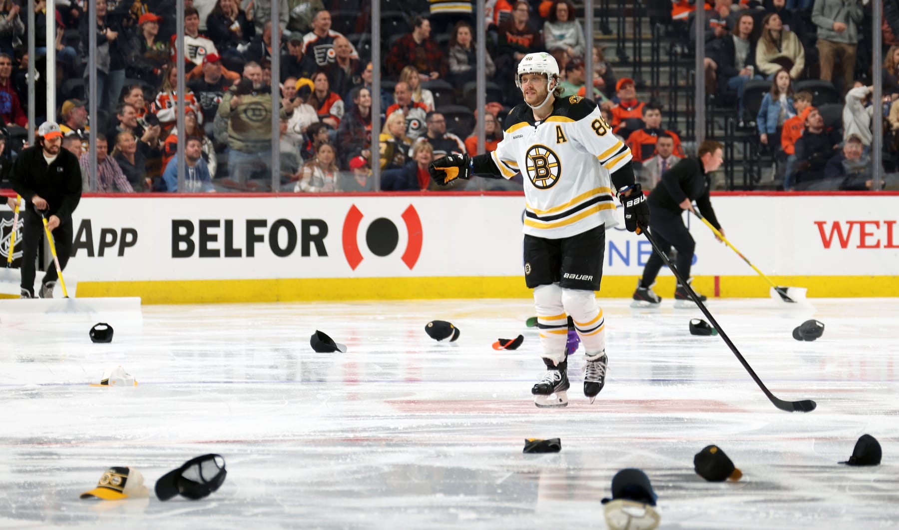PHILADELPHIA, PENNSYLVANIA - APRIL 09:  David Pastrnak #88 of the Boston Bruins skates through the hats on the ice with teammates following his third period goal against the Philadelphia Flyers at the Wells Fargo Center on April 9, 2023 in Philadelphia, Pennsylvania.  The goal was Pastrnak's third of the game, earning him a hat-trick.  The goal was the 60th regular season and the 300th of Pastrnak's NHL career.  (Photo by Len Redkoles/NHLI via Getty Images)
