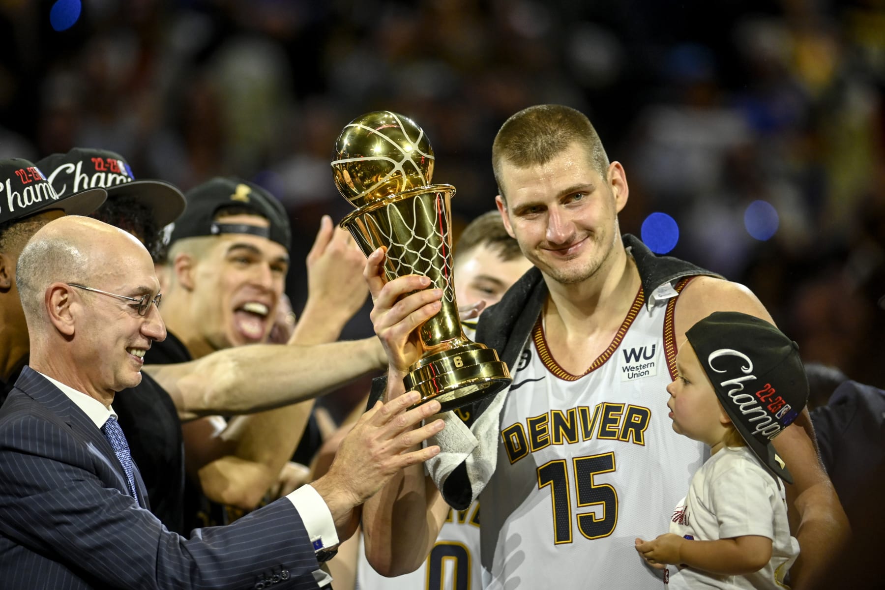 DENVER, CO - JUNE 12: NBA commissioner Adam Silver hands Nikola Jokic (15) of the Denver Nuggets the NBA Finals Most Valuable Player Award as the star holds his daughter, Ognjena, after the fourth quarter of the Nuggets' 94-89 NBA Finals clinching win over the Miami Heat at Ball Arena in Denver on Monday, June 12, 2023. (Photo by AAron Ontiveroz/The Denver Post)
