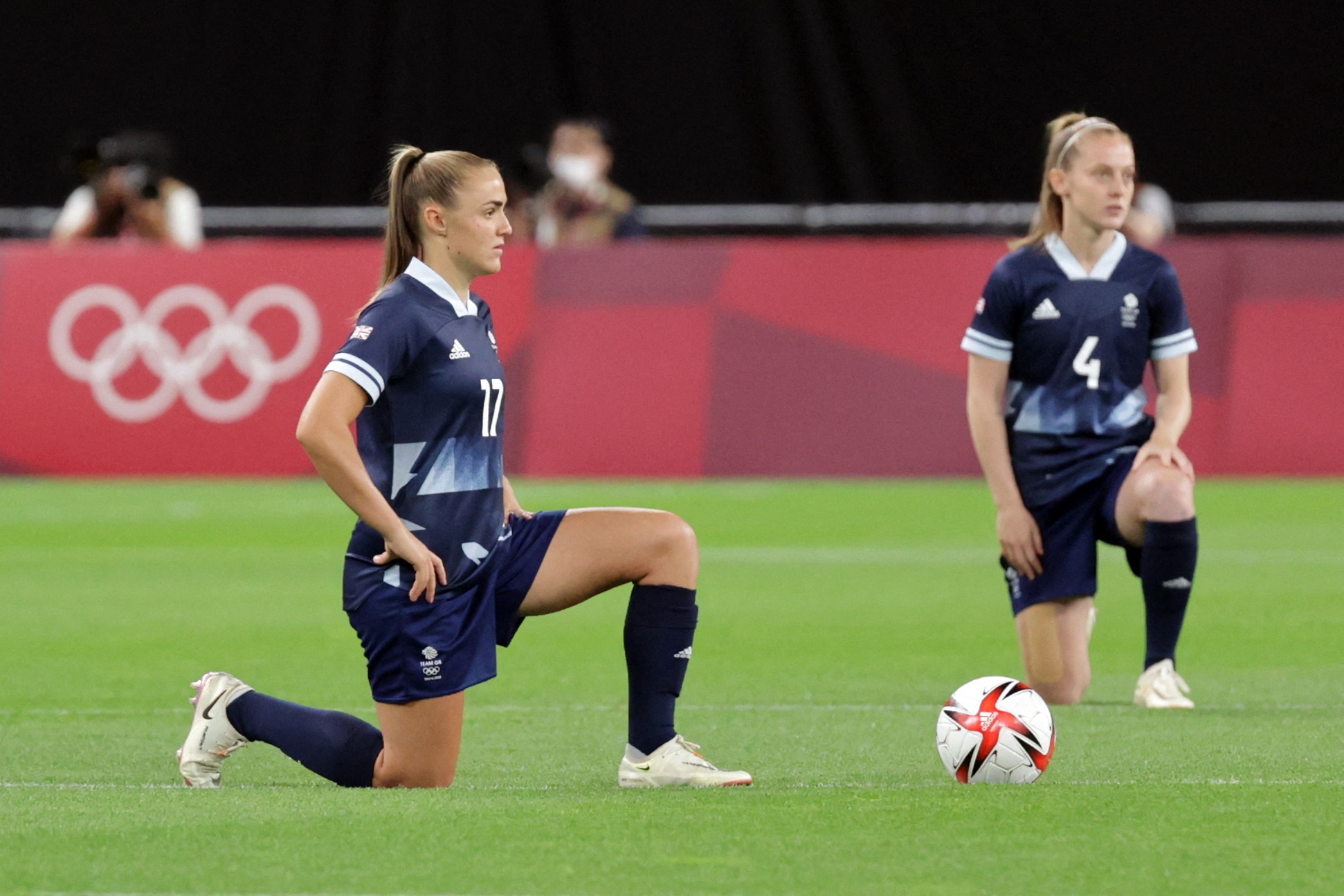 TOPSHOT - Britain's forward Georgia Stanway (L) and Britain's midfielder Keira Walsh take a knee before the Tokyo 2020 Olympic Games women's group E first round football match between Great Britain and Chile at the Sapporo Dome in Sapporo on July 21, 2021. (Photo by ASANO IKKO and - / AFP) (Photo by ASANO IKKO/AFP via Getty Images)