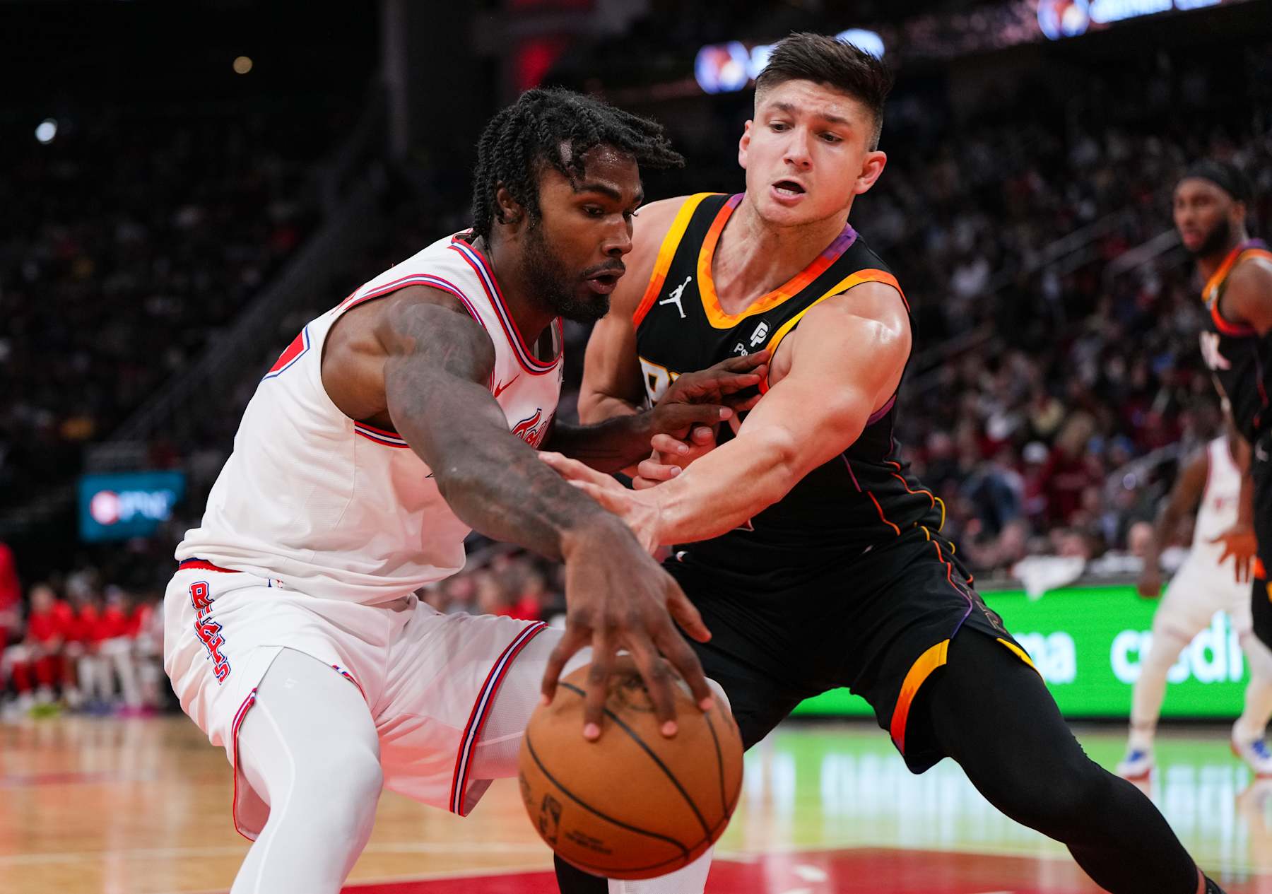 HOUSTON, TEXAS - DECEMBER 27: Tari Eason #17 of the Houston Rockets dribbles the ball as Grayson Allen #8 of the Phoenix Suns defends during the third quarter of the game at Toyota Center on December 27, 2023 in Houston, Texas. User expressly acknowledges and agrees that, by downloading and or using this photograph, User is consenting to the terms and conditions of the Getty Images License Agreement. (Photo by Alex Bierens de Haan/Getty Images)