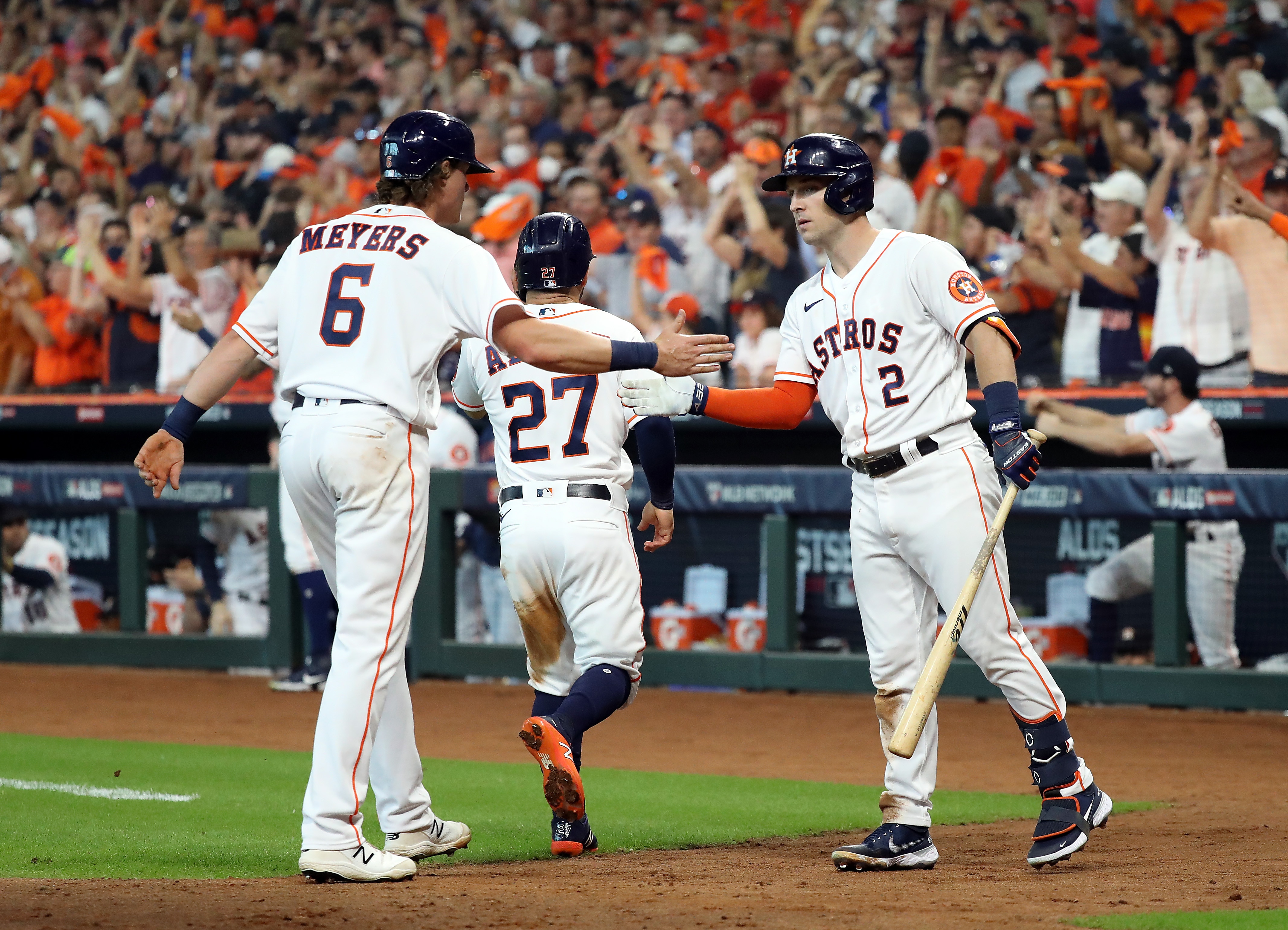 HOUSTON, TEXAS - OCTOBER 07:  Jake Meyers #6 and Jose Altuve #27 of the Houston Astros are congratulated at home plate by Alex Bregman #2 after scoring during the 4th inning of Game 1 of the American League Division Series against the Chicago White Sox at Minute Maid Park on October 07, 2021 in Houston, Texas. (Photo by Bob Levey/Getty Images)