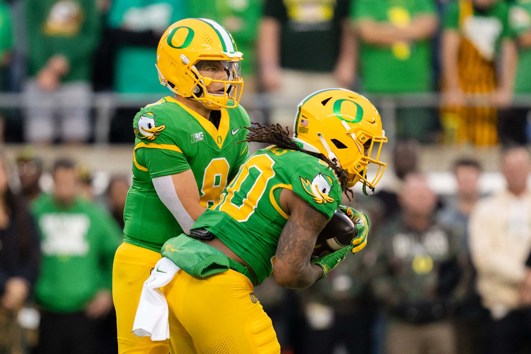 EUGENE, OREGON - NOVEMBER 9: Quarterback Dillon Gabriel #8 hands off the ball to running back Jordan James #20 of the Oregon Ducks during the first half of the game against the Maryland Terrapins at Autzen Stadium on November 9, 2024 in Eugene, Oregon. (Photo by Ali Gradischer/Getty Images)