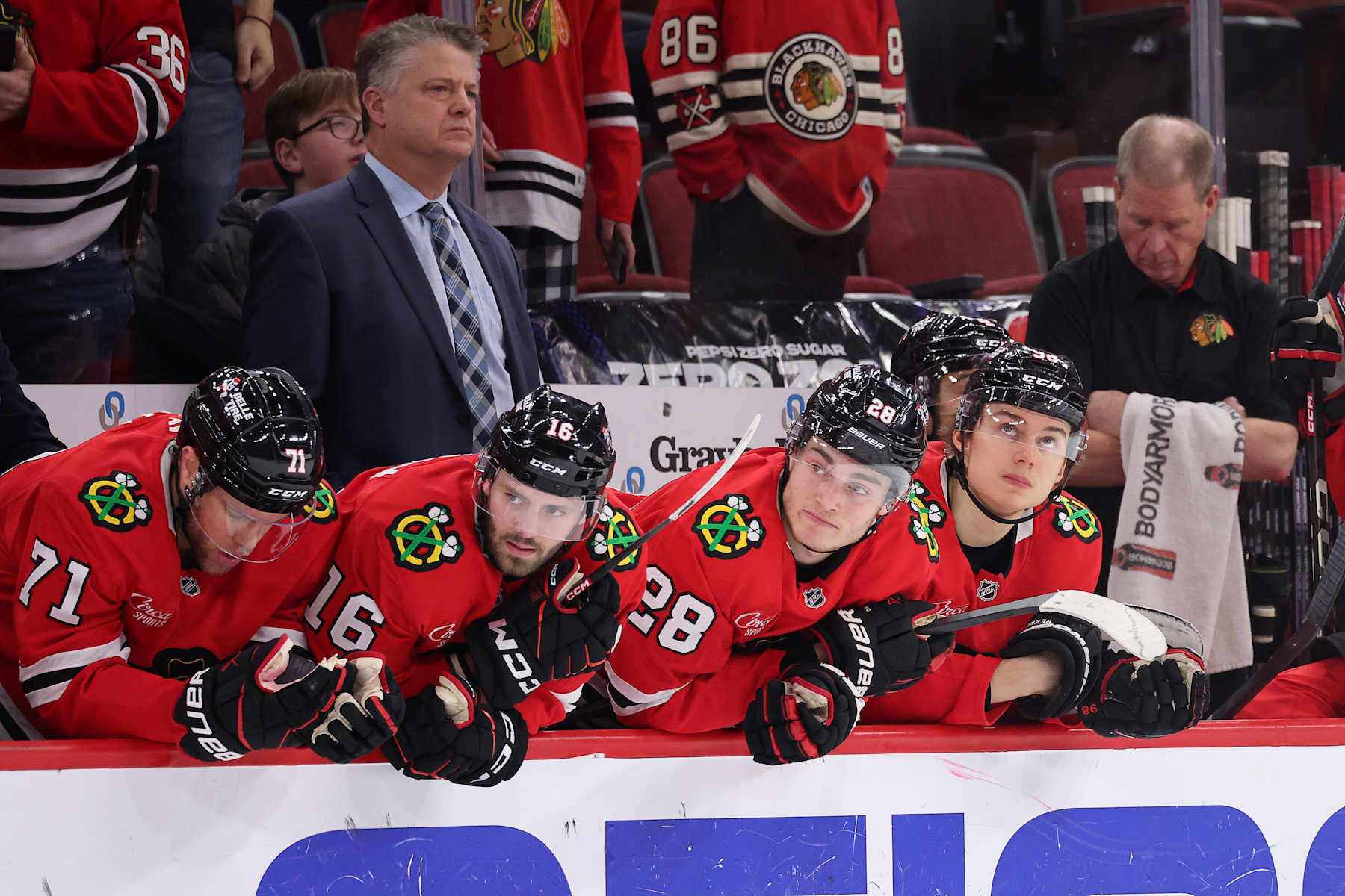 CHICAGO, ILLINOIS - JANUARY 05: Taylor Hall #71, Jason Dickinson #16, Colton Dach #28 and Connor Bedard #98 of the Chicago Blackhawks look on against the New York Rangers during the third period at the United Center on January 05, 2025 in Chicago, Illinois. (Photo by Michael Reaves/Getty Images)