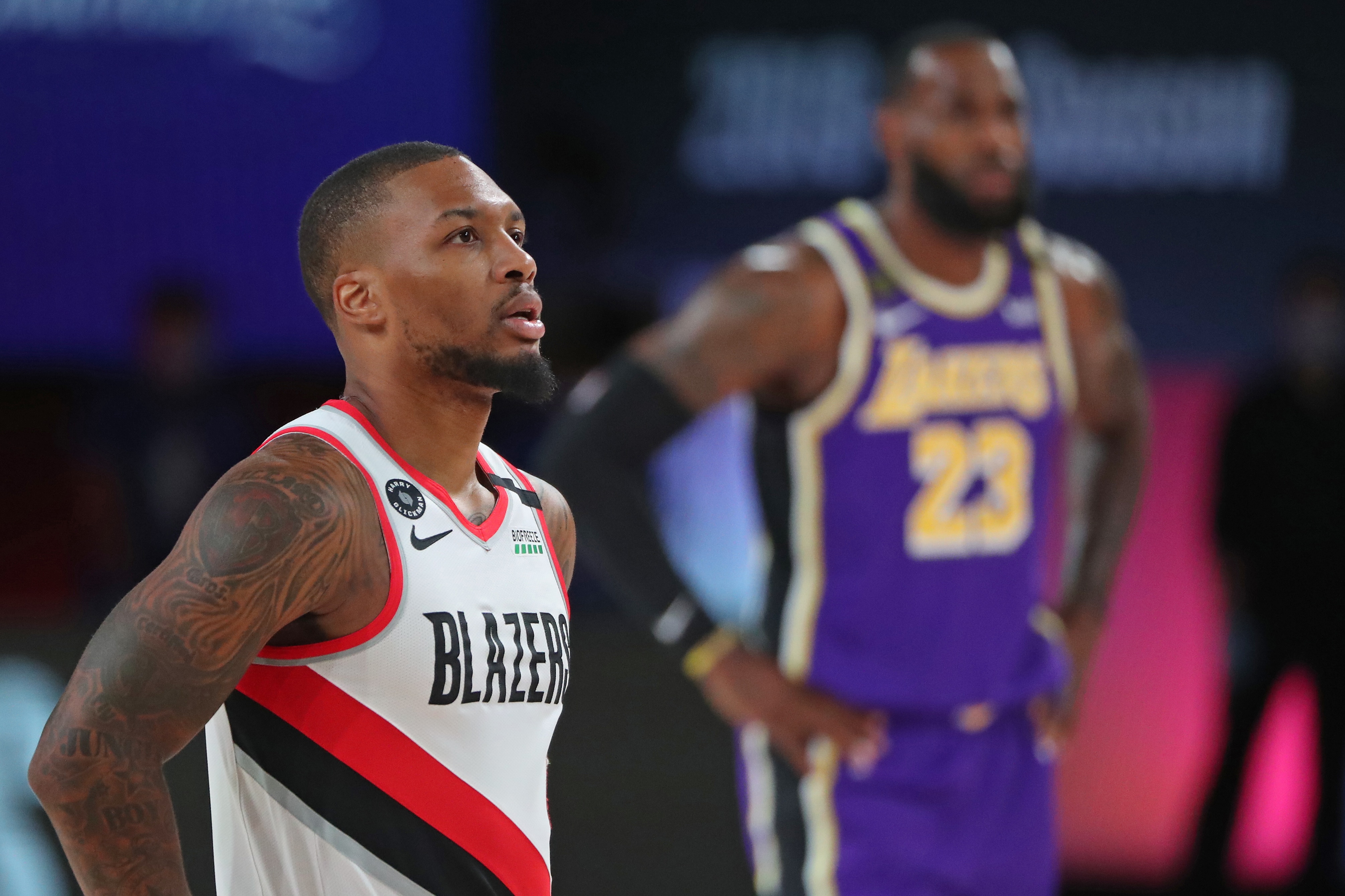 Orlando, FL - AUGUST 22:  Damian Lillard #0 of the Portland Trail Blazers and LeBron James #23 of the Los Angeles Lakers look on during Round One, Game Three on August 22, 2020 in Orlando, Florida at the AdventHealth Arena. NOTE TO USER: User expressly acknowledges and agrees that, by downloading and/or using this Photograph, user is consenting to the terms and conditions of the Getty Images License Agreement. Mandatory Copyright Notice: Copyright 2020 NBAE (Photo by Joe Murphy/NBAE via Getty Images)