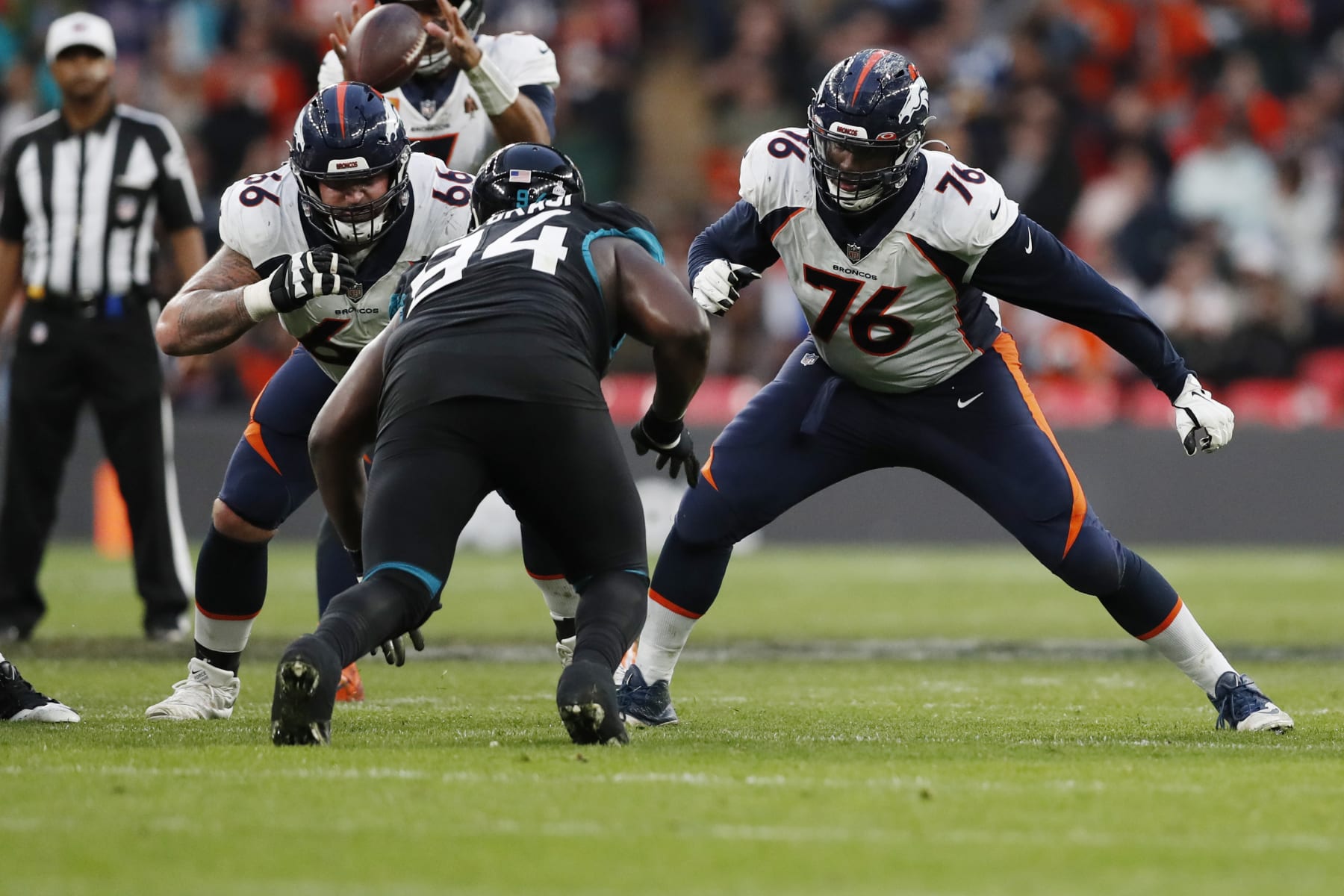 Denver Broncos guard Dalton Risner (66) and Denver Broncos offensive tackle Calvin Anderson (76) move in to block Jacksonville Jaguars defensive tackle Folorunso Fatukasi (94) during an NFL football game at Wembley Stadium in London, Sunday, Oct. 30, 2022. The Denver Broncos defeated the Jacksonville Jaguars 21-17. (AP Photo/Steve Luciano)