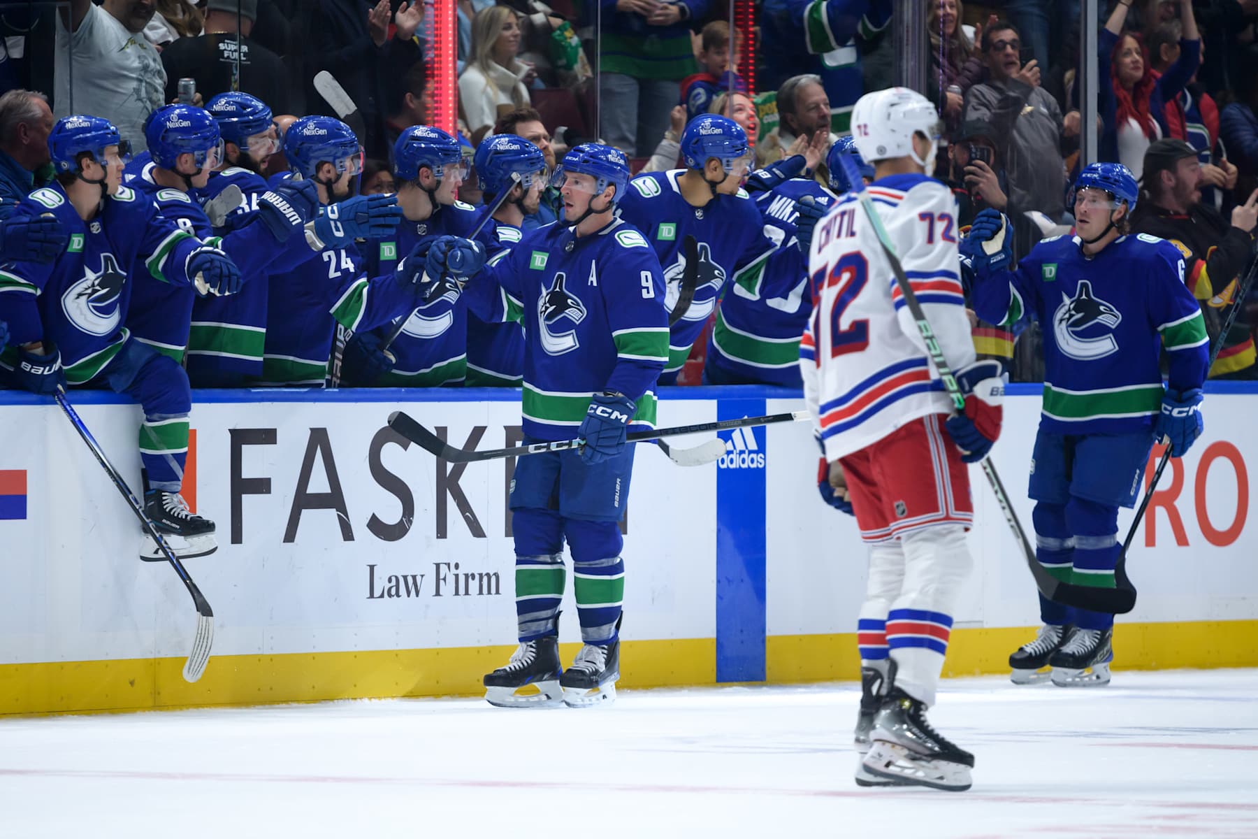 VANCOUVER, CANADA - OCTOBER 28: J.T. Miller #9 of the Vancouver Canucks is congratulated at the players bench after scoring a goal as Filip Chytil #72 of the New York Rangers skates on during the second period of their NHL game at Rogers Arena on October 28, 2023 in Vancouver, British Columbia, Canada. (Photo by Derek Cain/Getty Images)