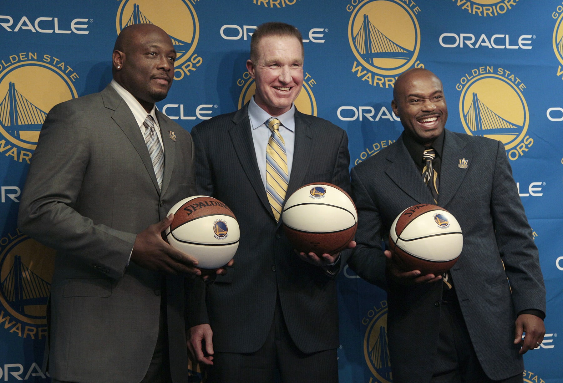 FILE - In this March 19, 2012, file photo, former Golden State Warriors players, from left, Mitch Richmond, Chris Mullin and Tim Hardaway pose after a news conference before an NBA basketball game between the Warriors and the Minnesota Timberwolves, in Oakland, Calif. Chris Mullin and Tim Hardaway spent two seasons as teammates at Oracle Arena, back when it was called the Oakland–Alameda County Coliseum Arena. The nostalgia is flooding back this week. The Warriors move across the bay from Oakland to San Francisco next season and start playing their games at the glistening new Chase Center, a building that will open in about three months. (AP Photo/Jeff Chiu, File)